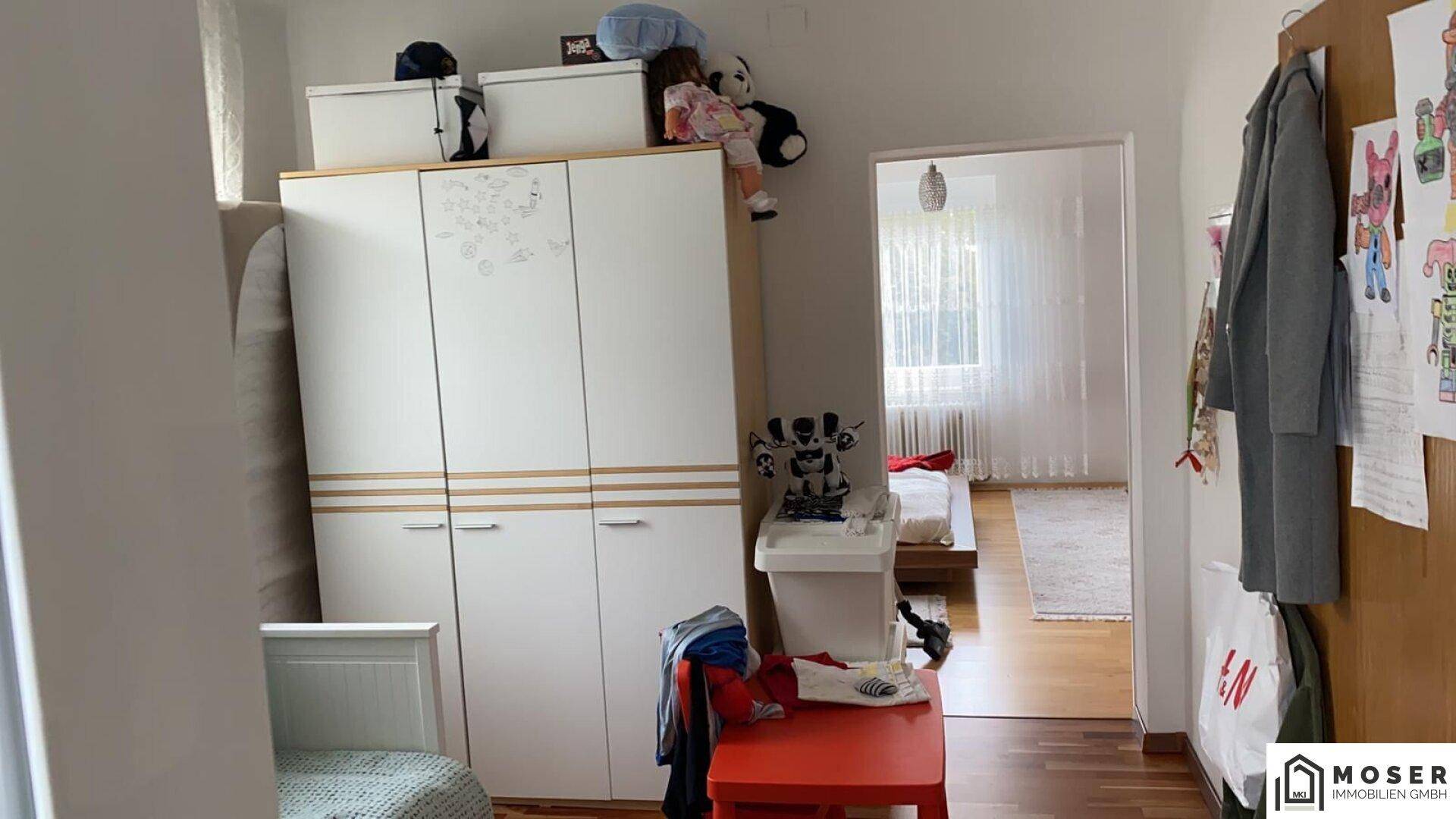 Innenraum mit Schrank und Türöffnung zu einem weiteren Zimmer.