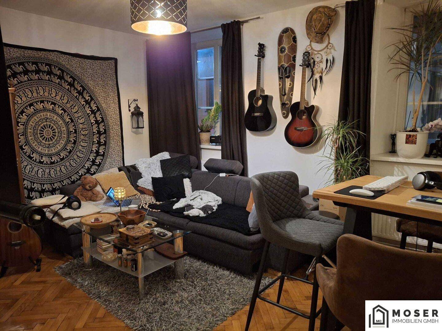 Gemütliches Wohnzimmer mit Sofa, Couchtisch, Wanddekoration und einem Arbeitsbereich.