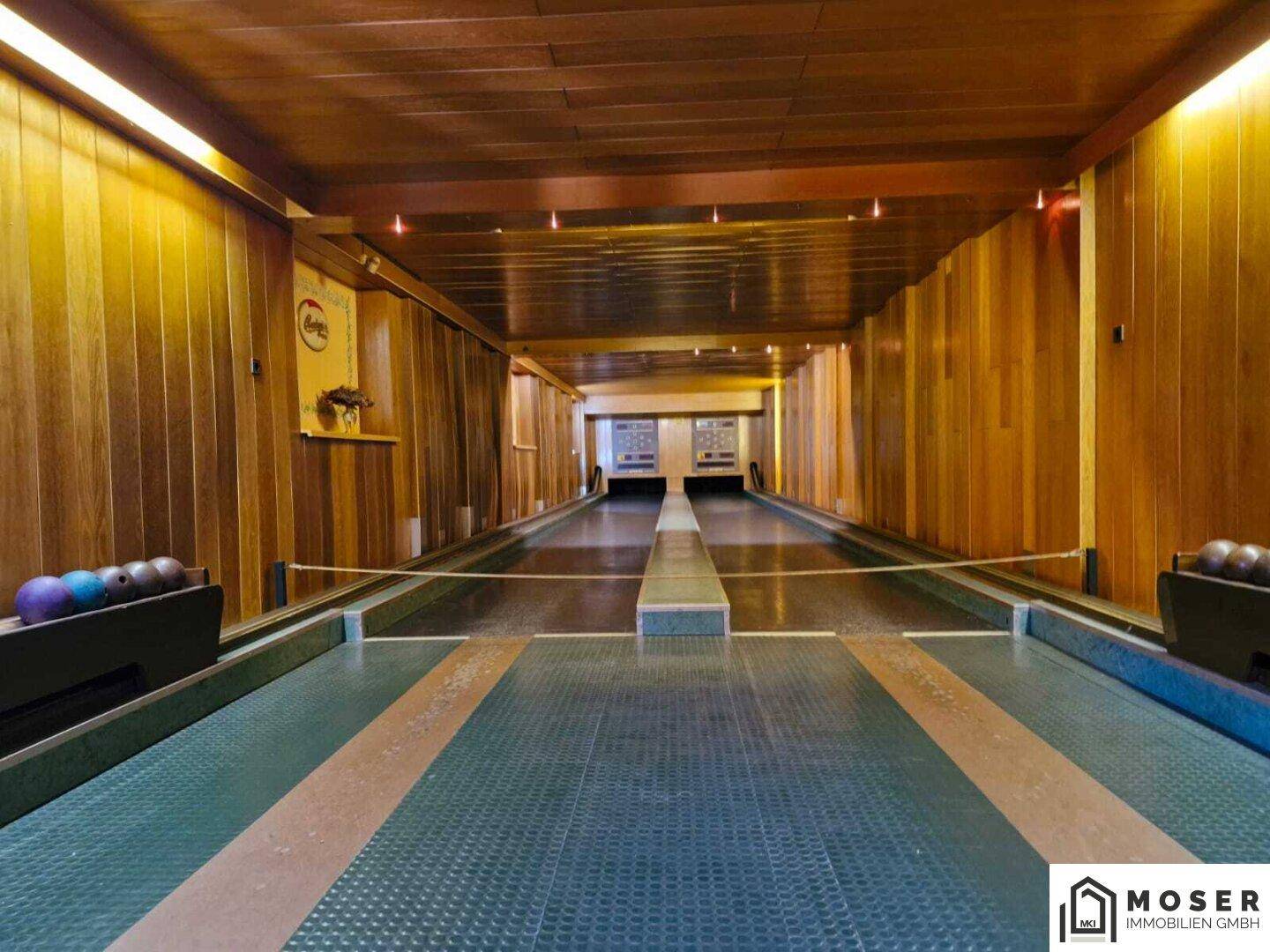Lange Kegelbahn mit Holzverkleidung an Wänden und Decke, ideal für Freizeitaktivitäten.