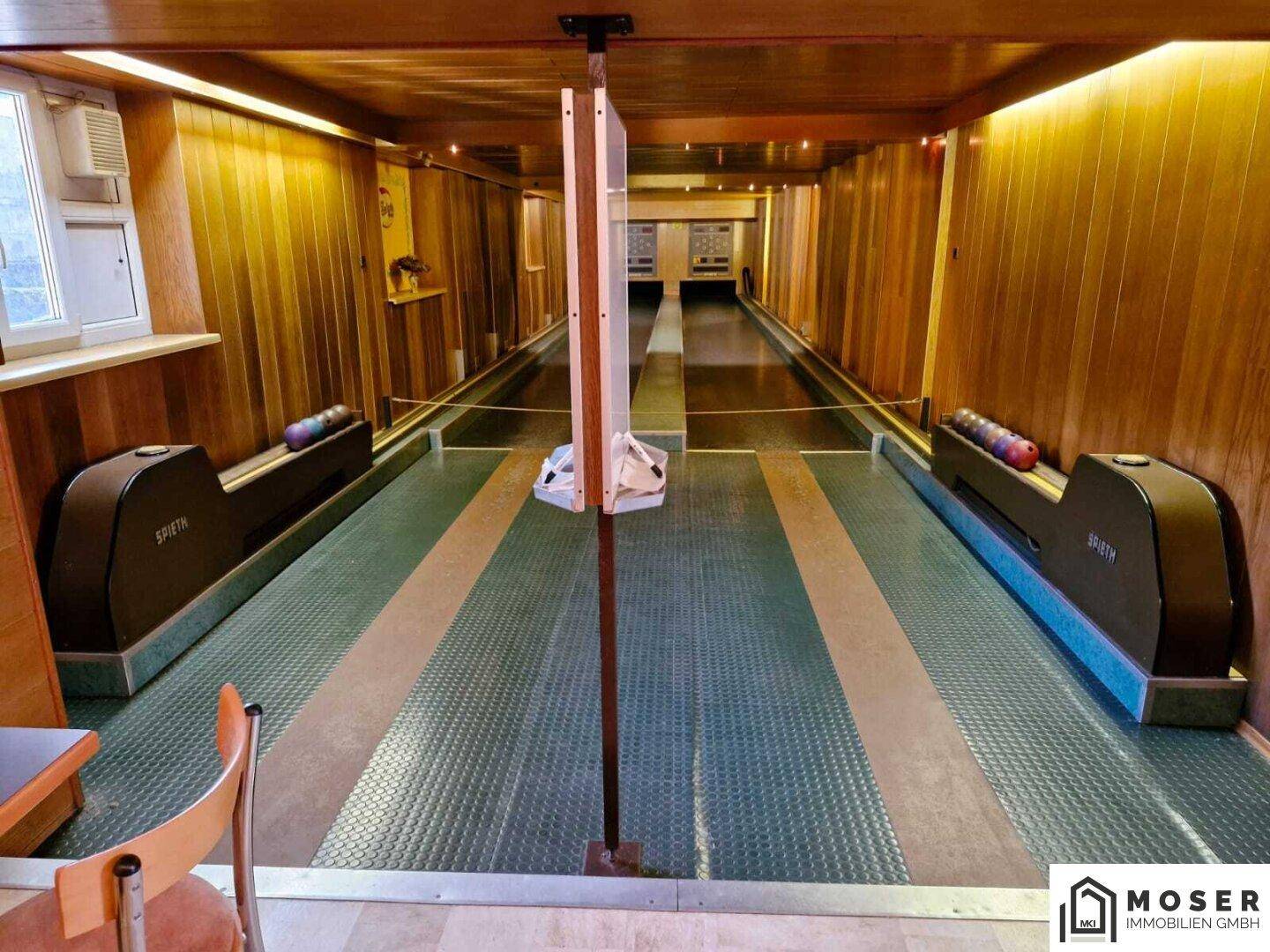 Ansicht der Kegelbahn mit zwei Bahnen, Fenster und Holzelementen, ideal für gesellige Runden.