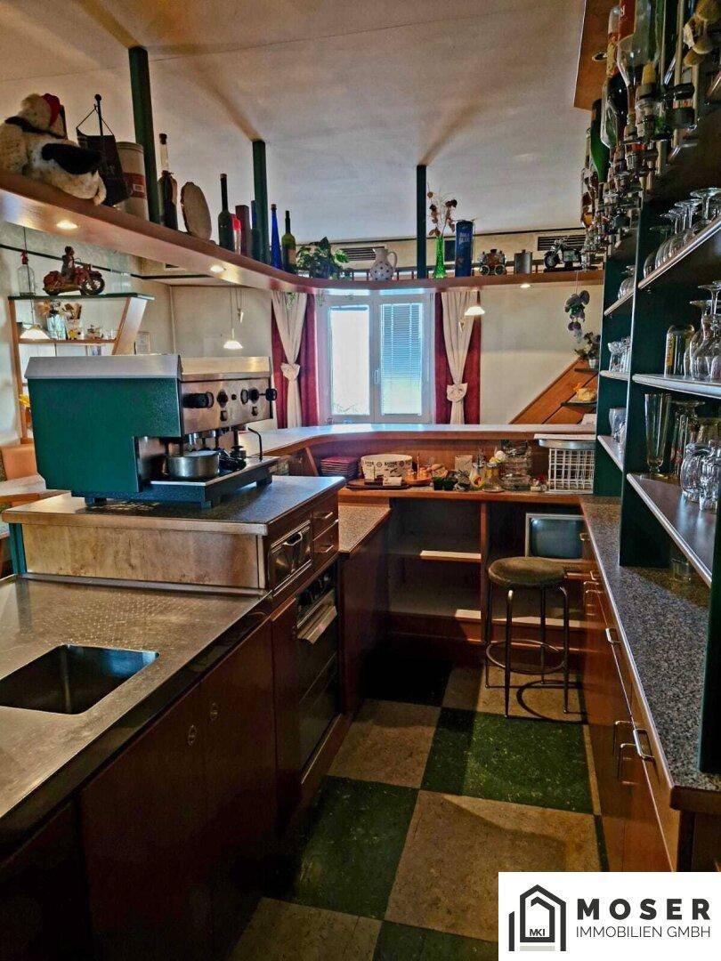 Bar- und Küchenbereich mit Kaffeemaschine, Spüle und kariertem Boden, gut ausgestattet.