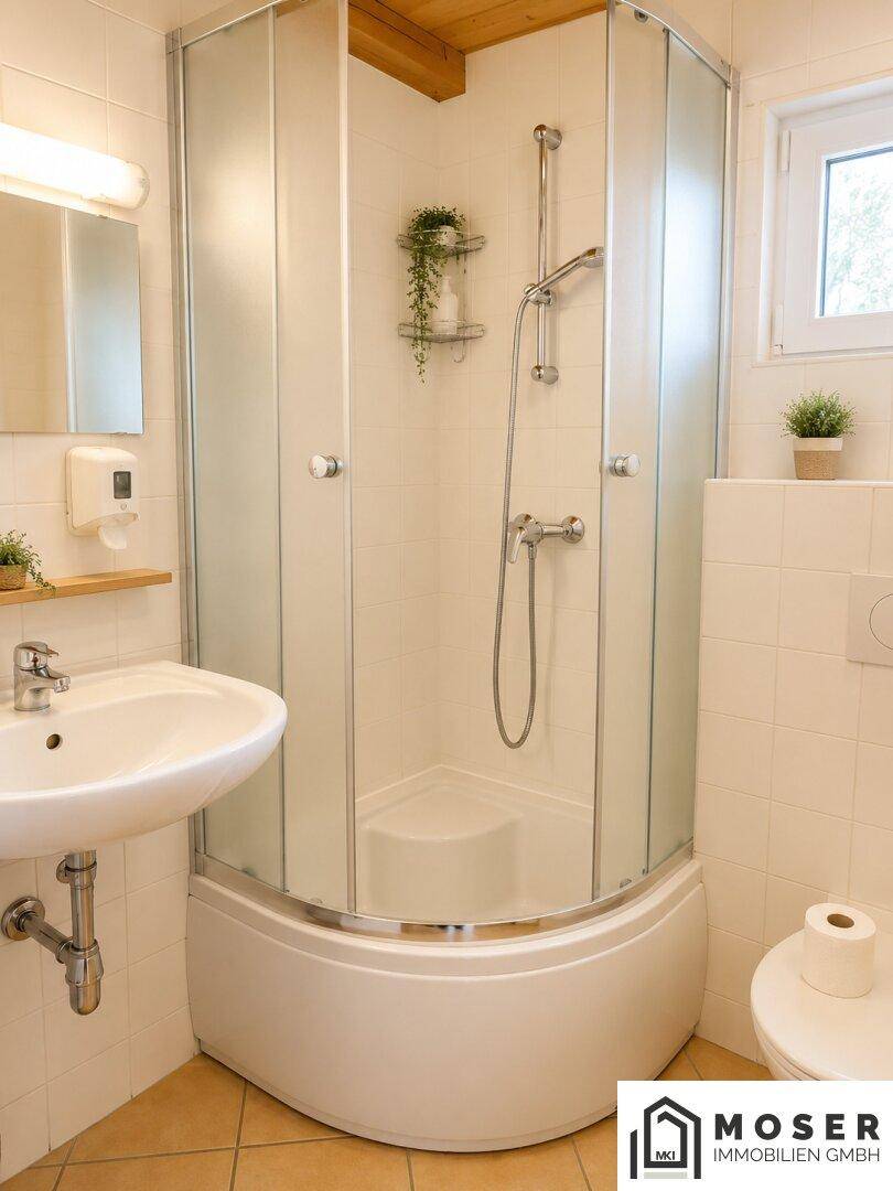 Funktionales Badezimmer mit Eckdusche, Waschbecken, WC und einem Fenster für Tageslicht.