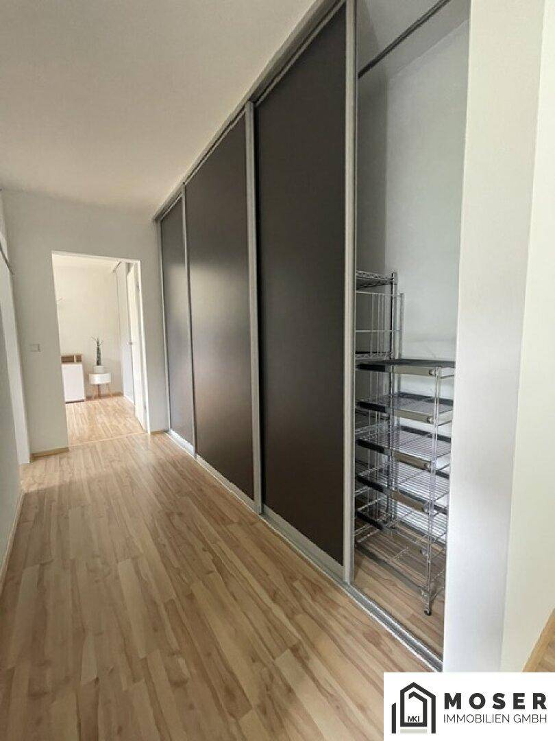 Heller Flur mit praktischen Einbauschränken und hellem Laminatboden.