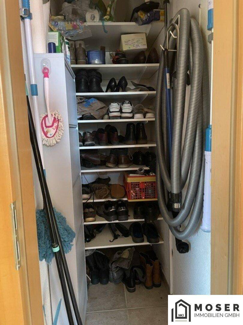 Kleiner Abstellraum mit Regalen für Schuhe und Reinigungsutensilien, praktisch organisiert.