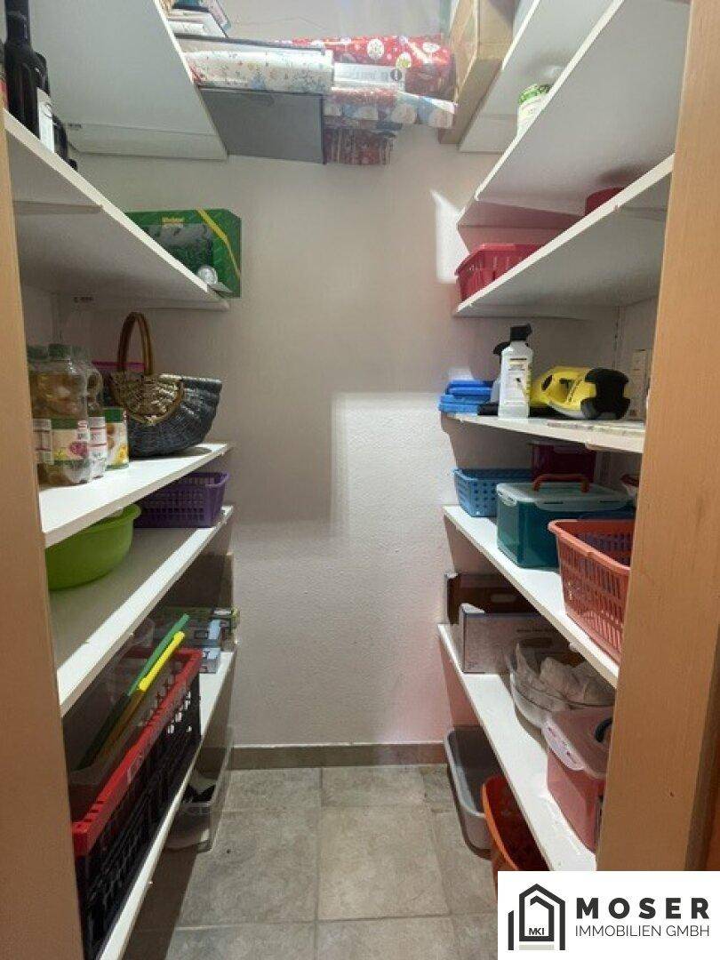 Gut organisierte Speisekammer mit Regalen voller Vorräte und Haushaltsartikeln.