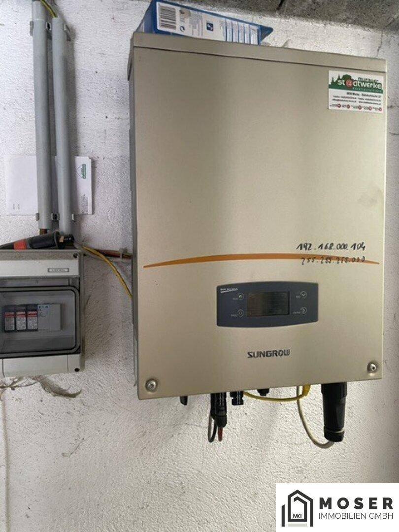 Solarwechselrichter an einer Wand in einem einfachen Technikraum installiert.