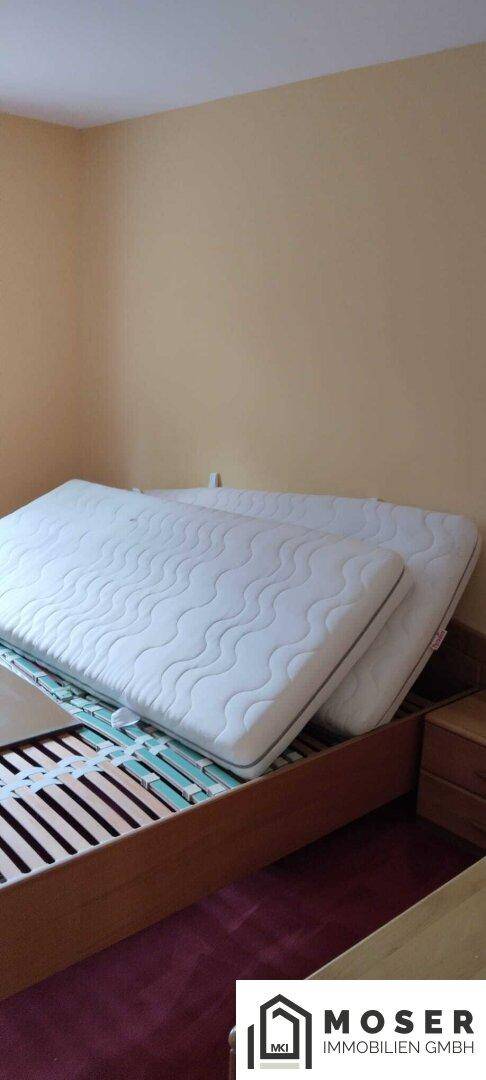 Schlafzimmer mit einfachem Bettgestell und Matratzen, bereit zur Einrichtung.