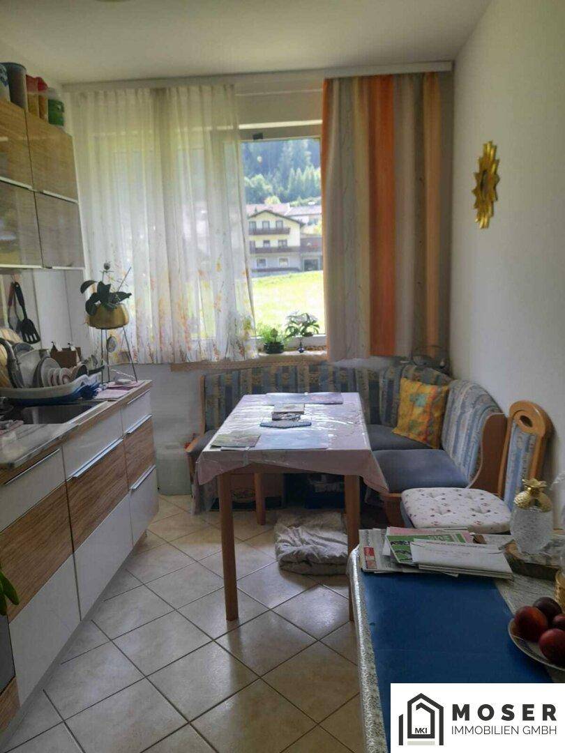 Wohnküche mit Essbereich, Fenster und Blick auf die grüne Umgebung, ideal für Mahlzeiten.