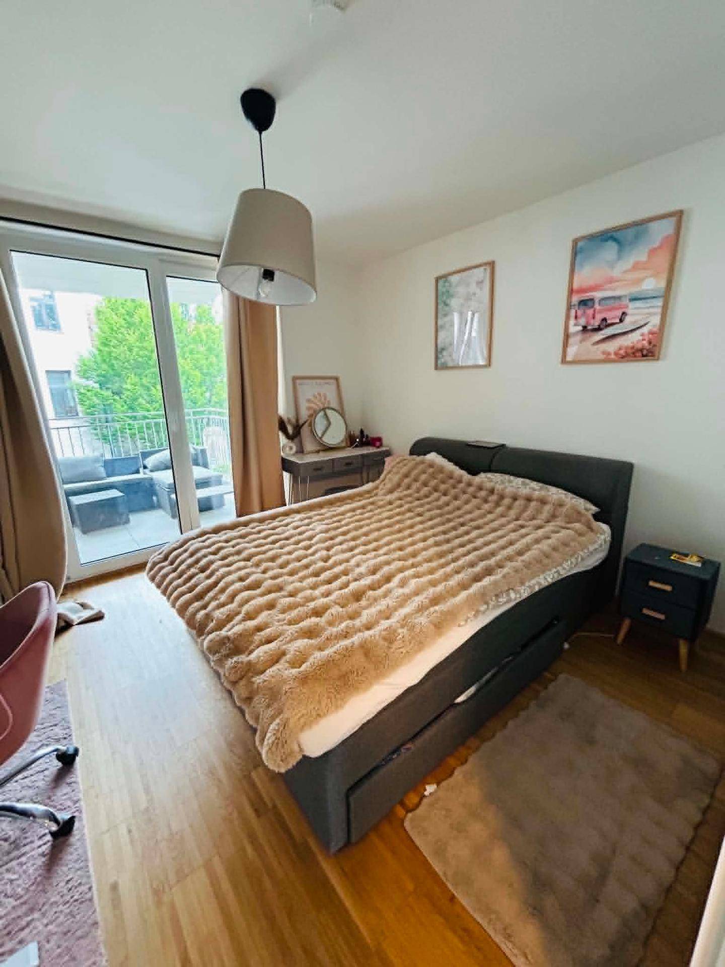 Helles Schlafzimmer mit großem Bett, Nachttischen und direktem Zugang zum Außenbereich.