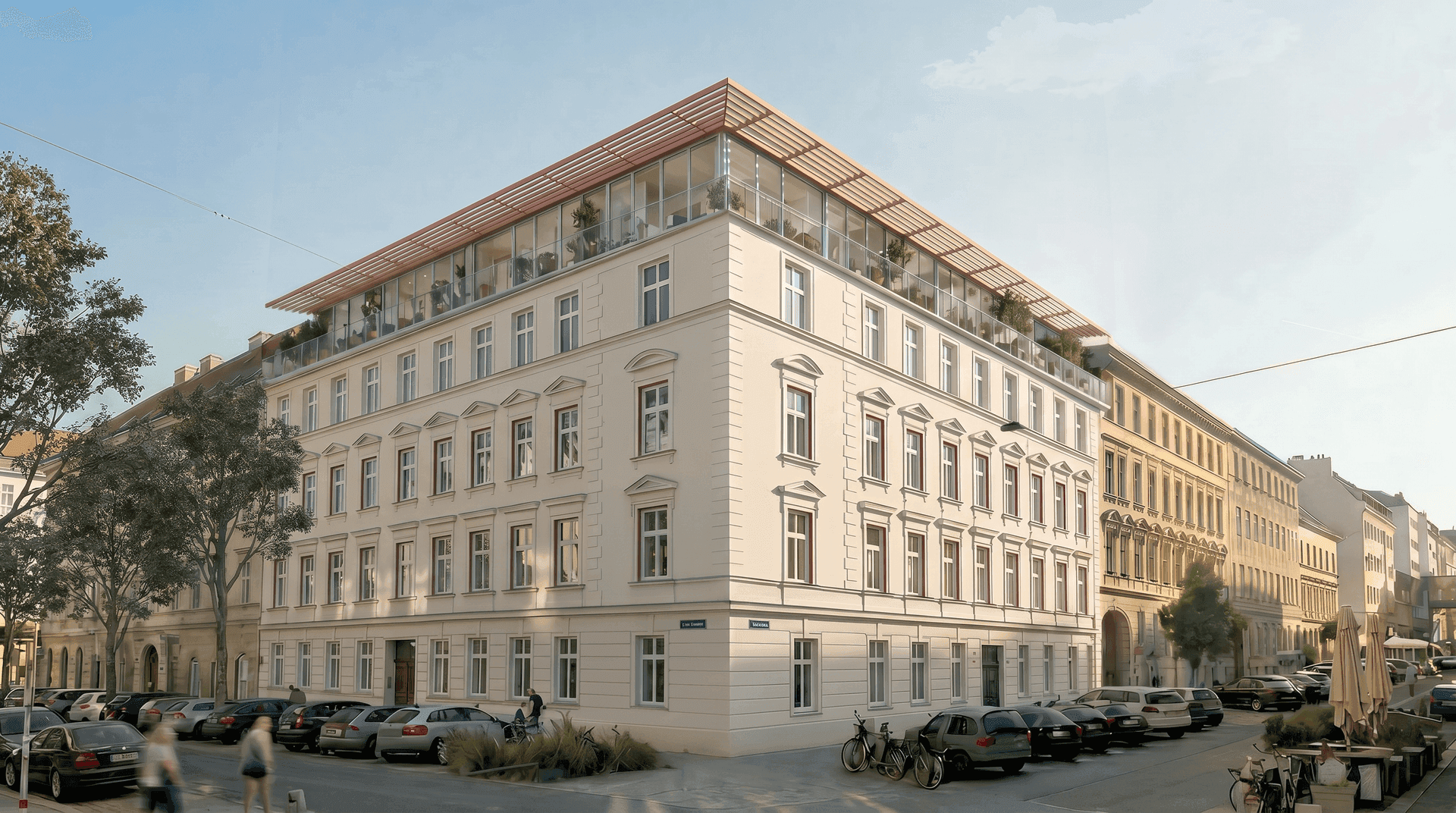 Elegantes Eckgebäude mit klassischer Fassade und moderner Dachaufstockung in urbaner Umgebung, mit Parkplätzen.