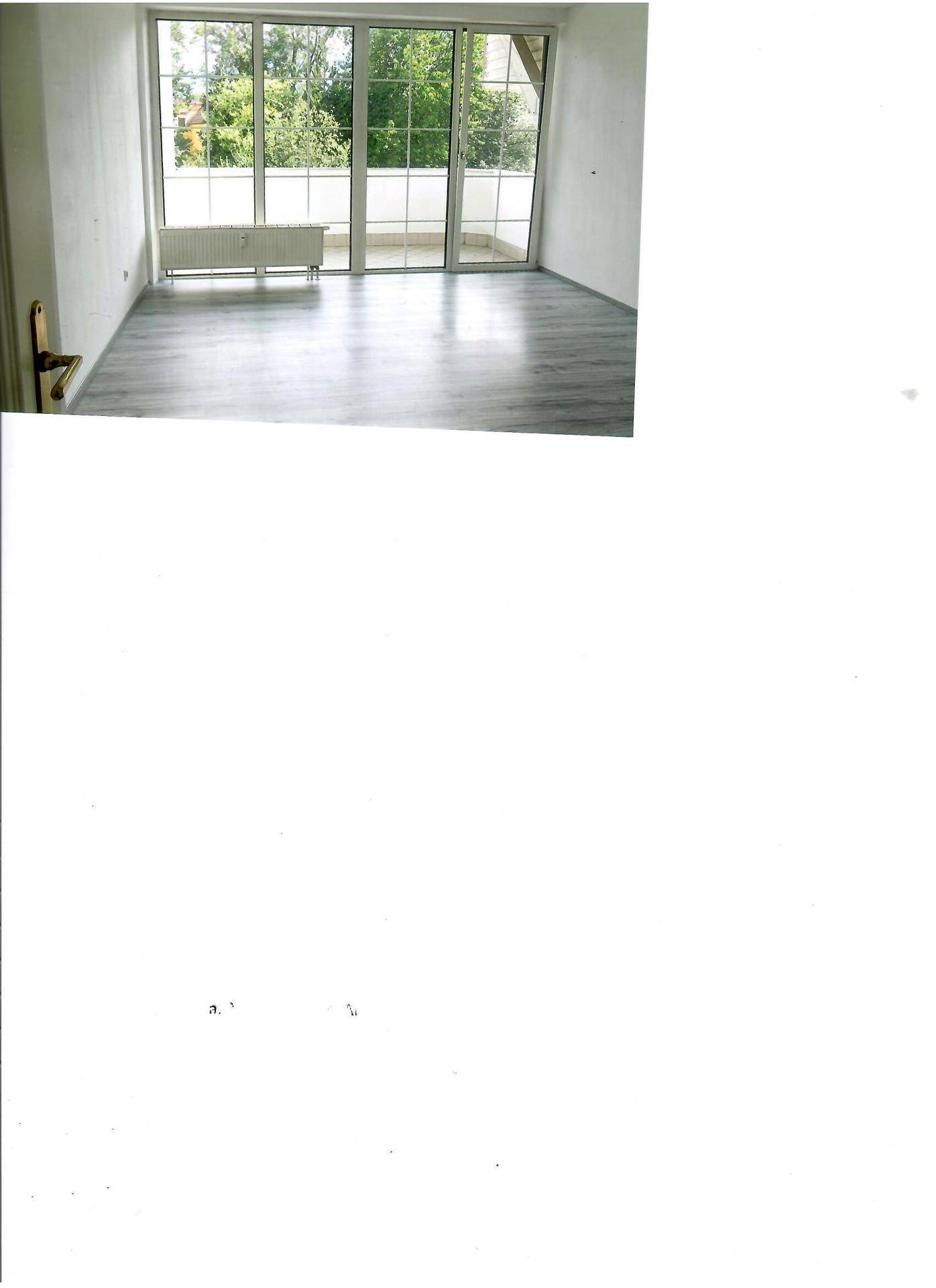 Geräumiges Zimmer mit hellem Laminatboden und großen Fenstern mit Zugang zum Außenbereich.