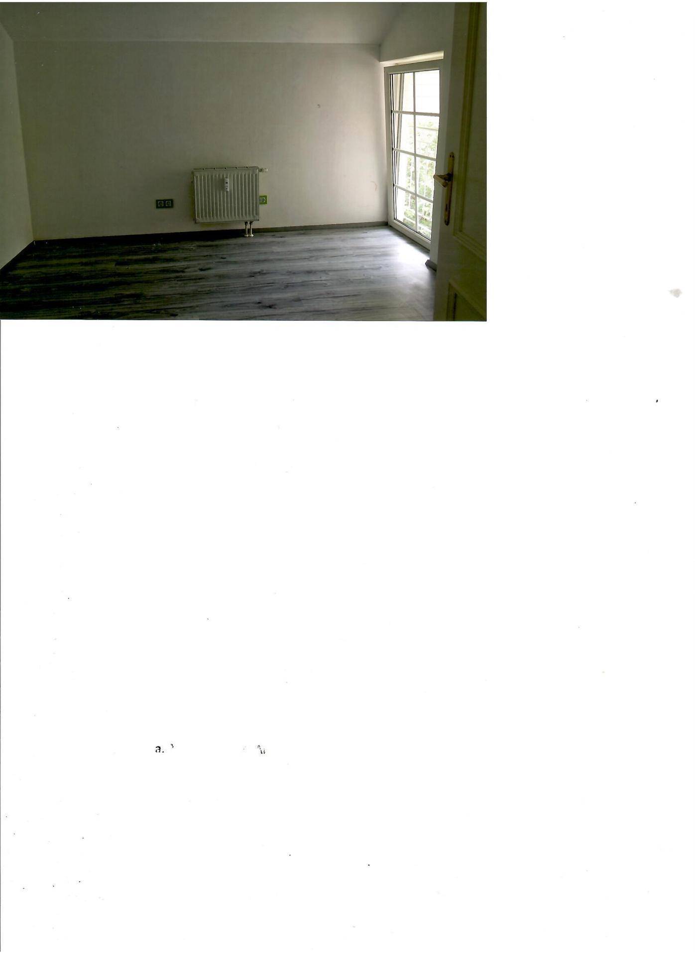 Freundliches Zimmer mit Laminatboden, Heizkörper und Zugang zu einem kleinen Außenbereich.