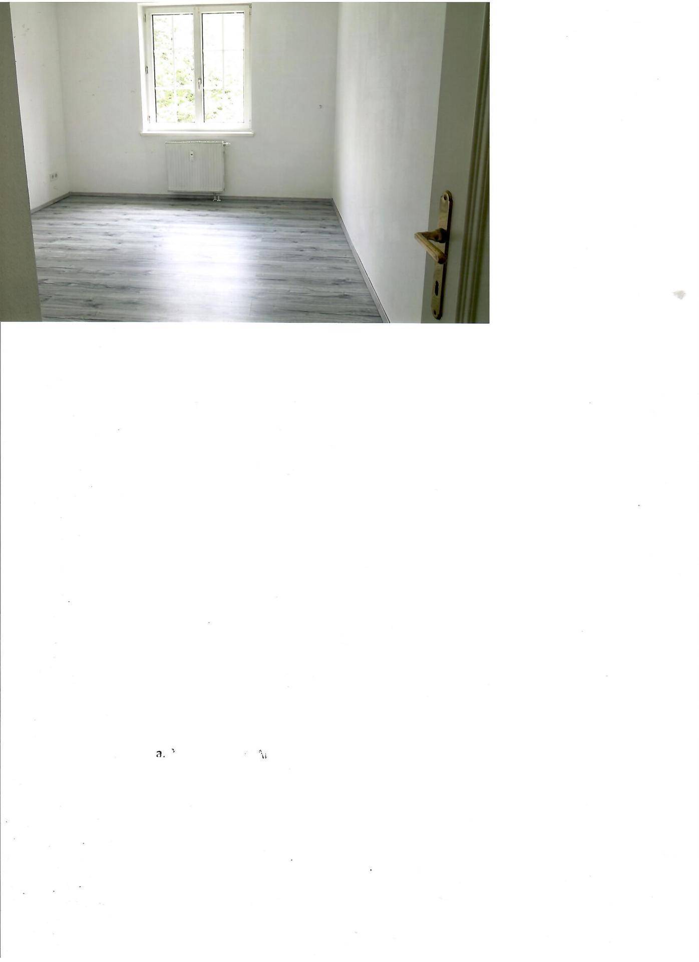 Helles Zimmer mit Laminatboden und großem Fenster, das viel Tageslicht hereinlässt.