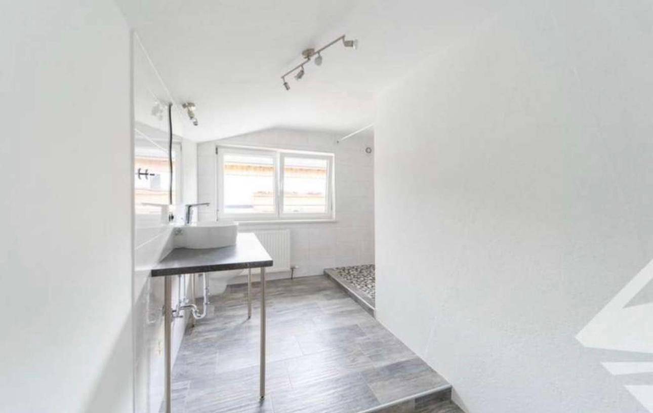 Modernes Badezimmer im Dachgeschoss mit begehbarer Dusche, Einzelwaschbecken und Fenster.