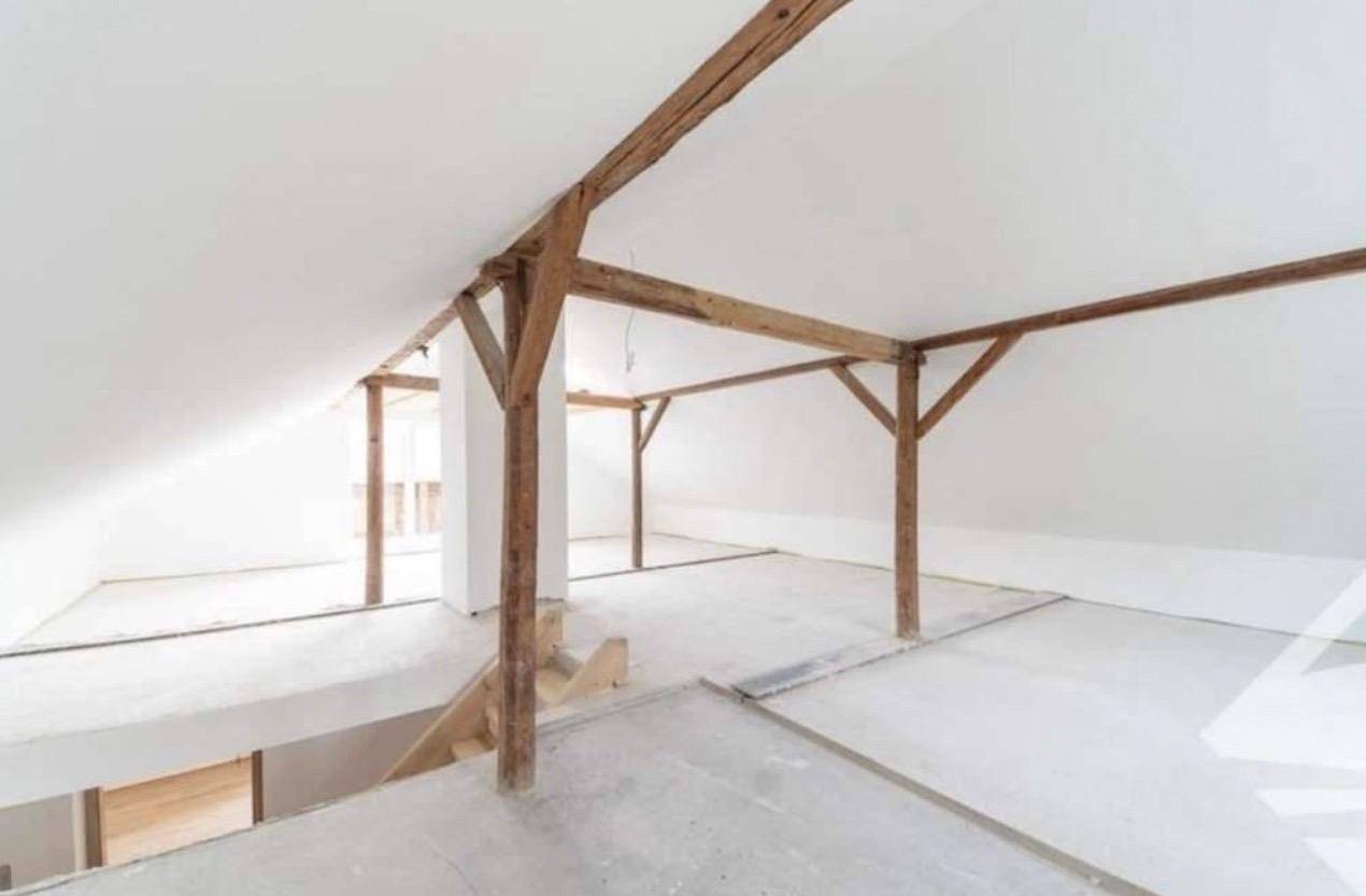 Ausbaufähiger Dachboden mit sichtbaren Holzbalken und schrägen Decken, bietet viel Potenzial.