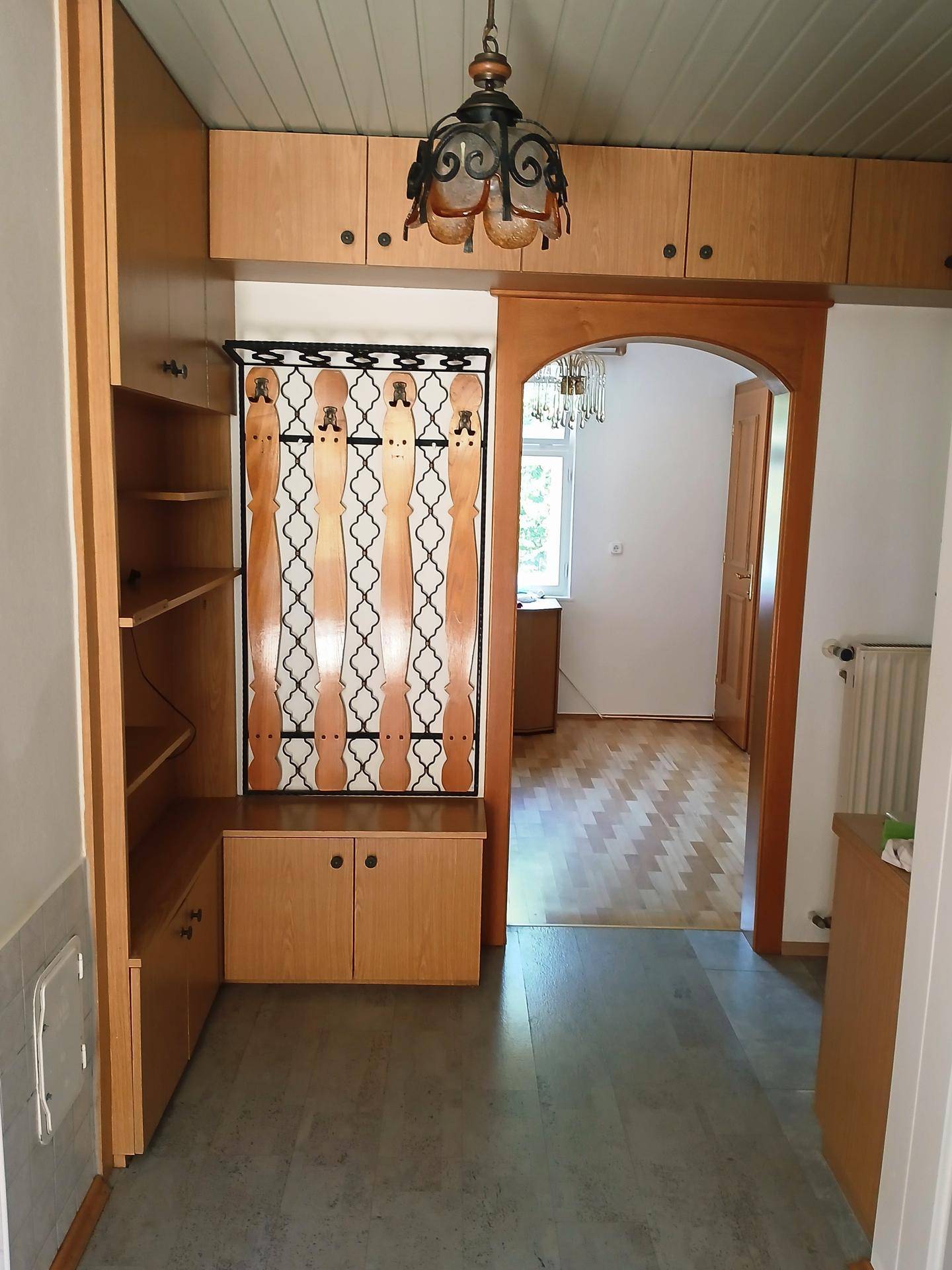 Traditioneller Flur mit Holzvertäfelung, Einbauschränken und einem Bogen zum nächsten Raum.