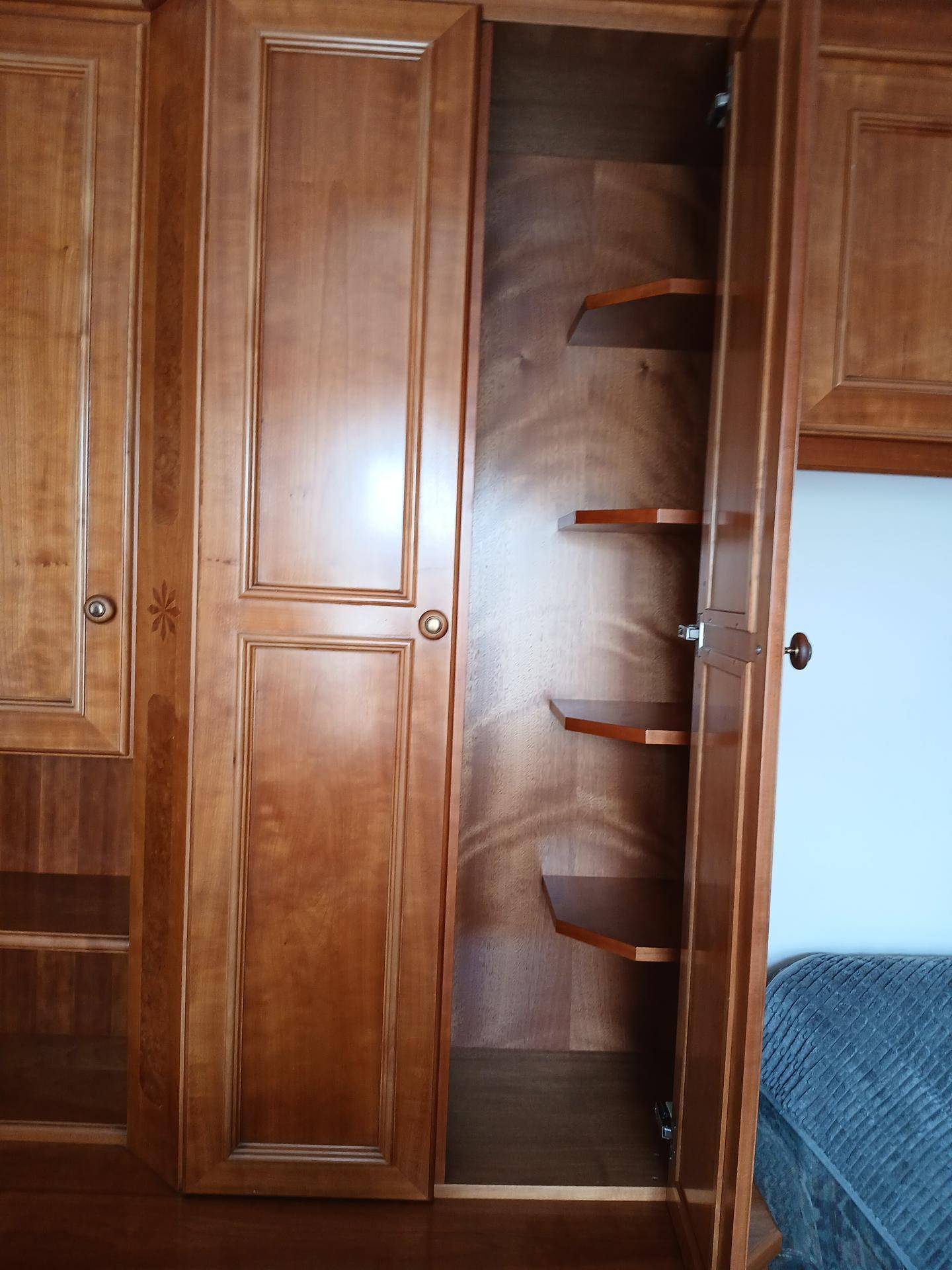Detailansicht der maßgefertigten Holzschränke mit integrierten Regalen im Wohnbereich.