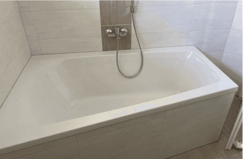 Helles Badezimmer mit integrierter Badewanne und modernen Fliesen.