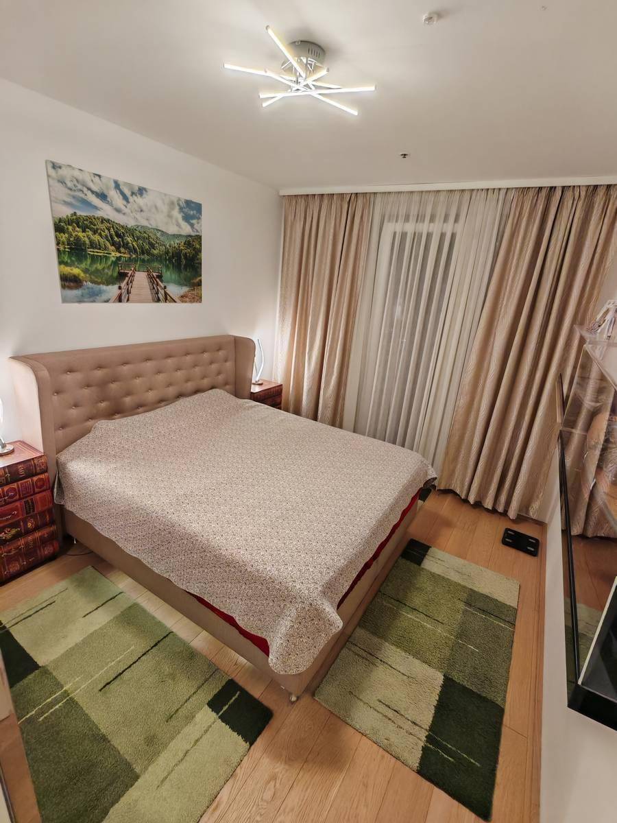 Gemütliches Schlafzimmer mit großem Doppelbett, Holzboden und dekorativen Teppichen.