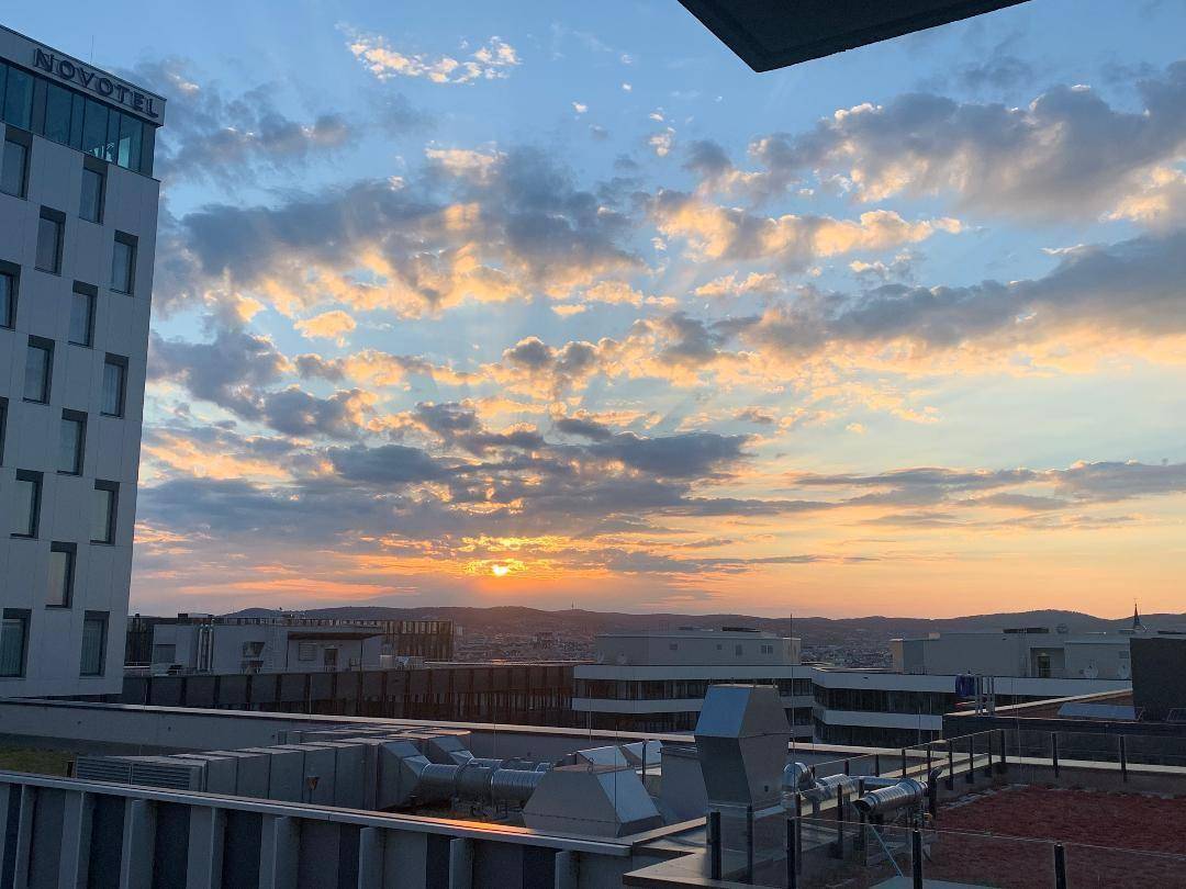 Spektakulärer Sonnenuntergang über der Stadt mit weitem Blick über die Dächer.
