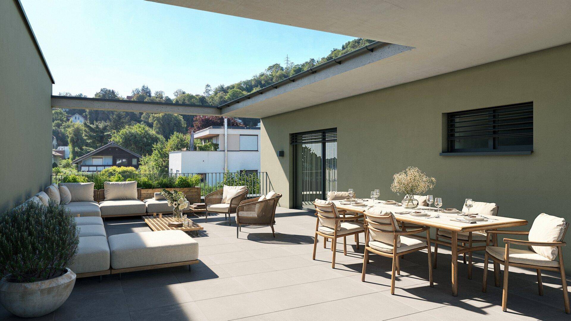 Großzügige, möblierte Terrasse mit Essbereich und Lounge-Möbeln, umgeben von grüner Natur.