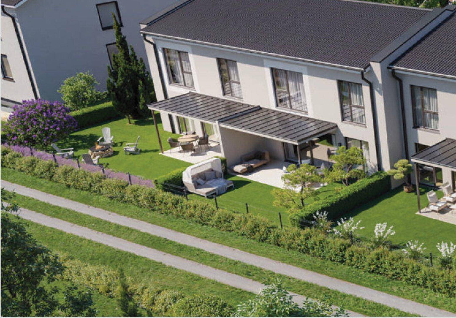 Luftaufnahme der Reihenhäuser mit überdachten Terrassen und weitläufigen Gärten.