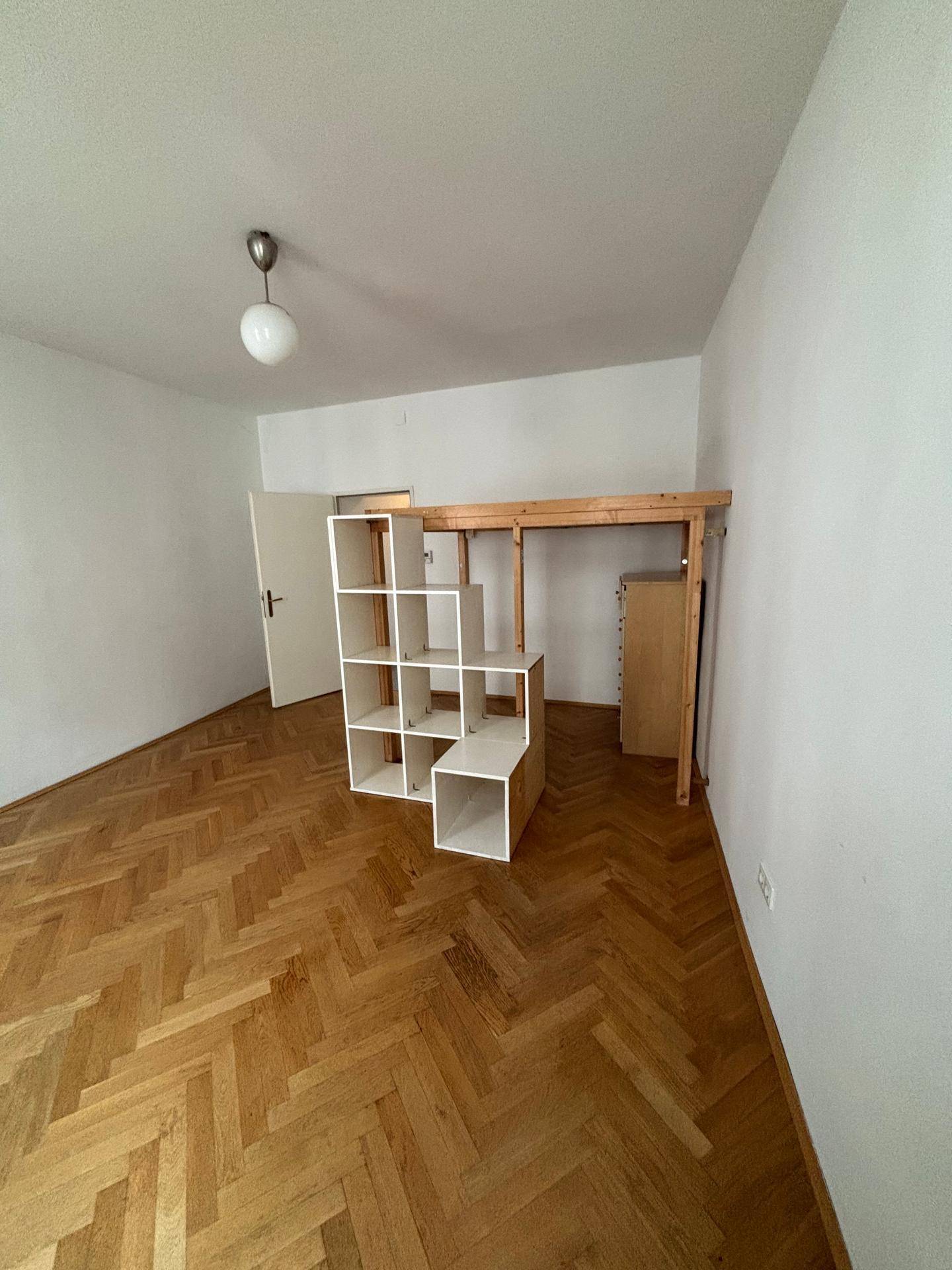 Wohnraum mit klassischem Fischgrätparkett und einer platzsparenden Hochbettlösung, hell und geräumig.
