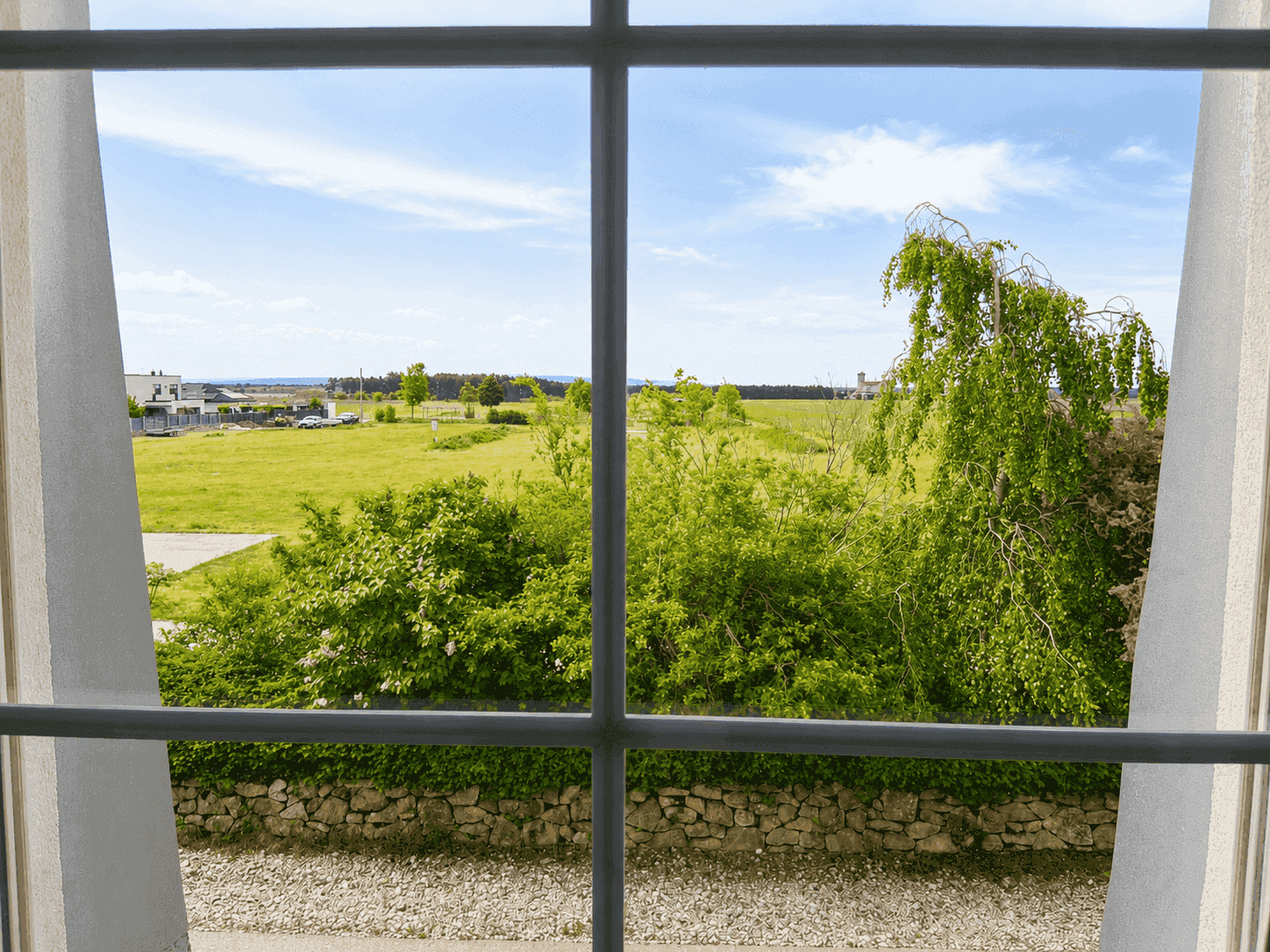 Blick aus dem Fenster auf weite Felder und die ländliche Umgebung.