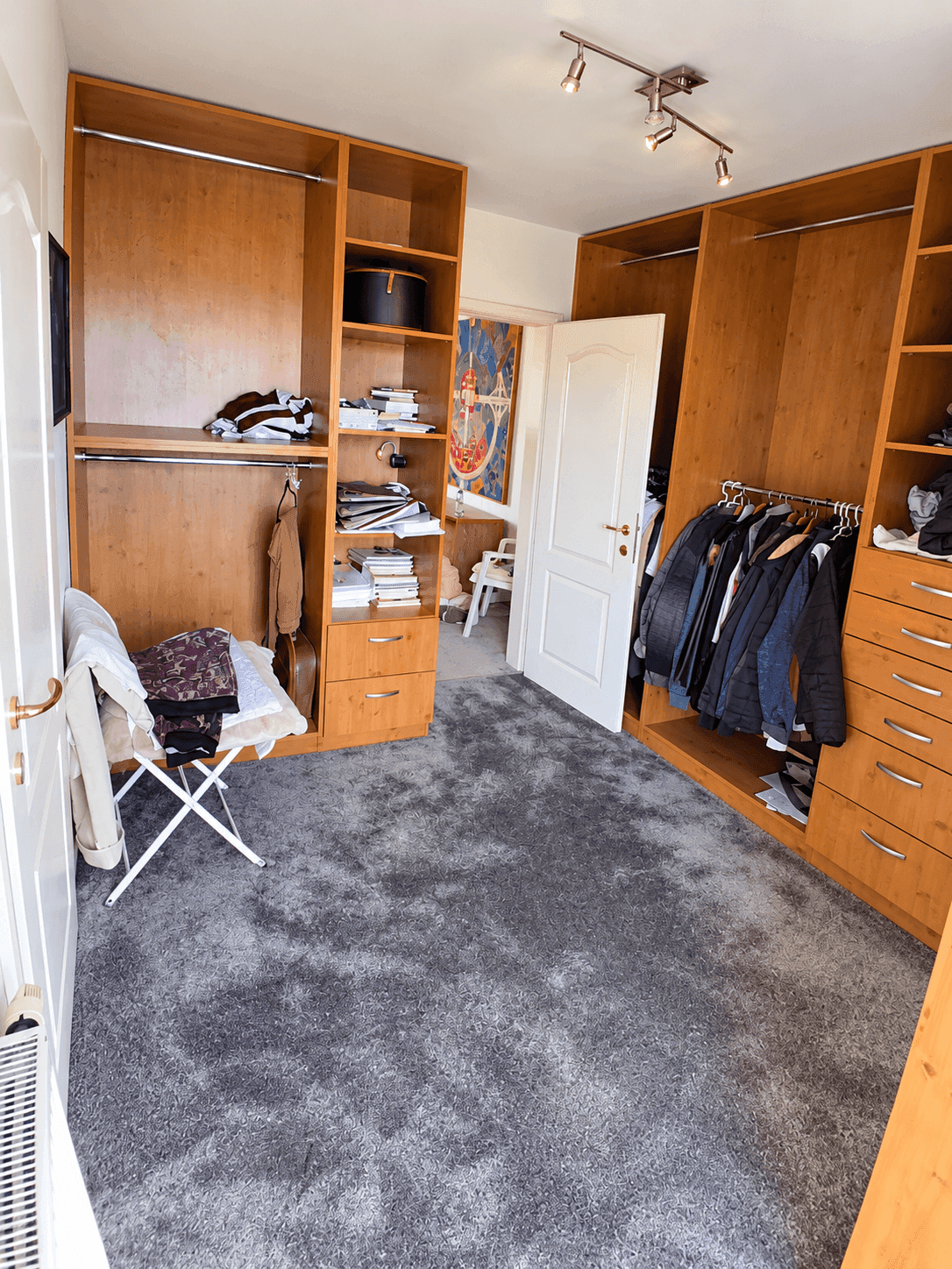 Geräumiger begehbarer Kleiderschrank mit offenen Regalen und viel Stauraum.