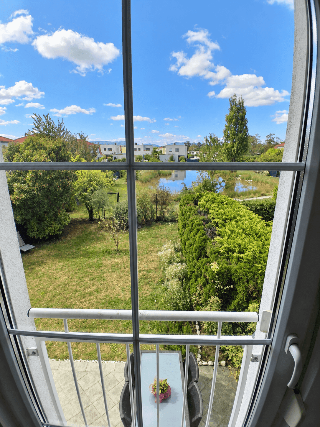 Ausblick vom französischen Balkon auf den Garten und die umliegende Wohnsiedlung.