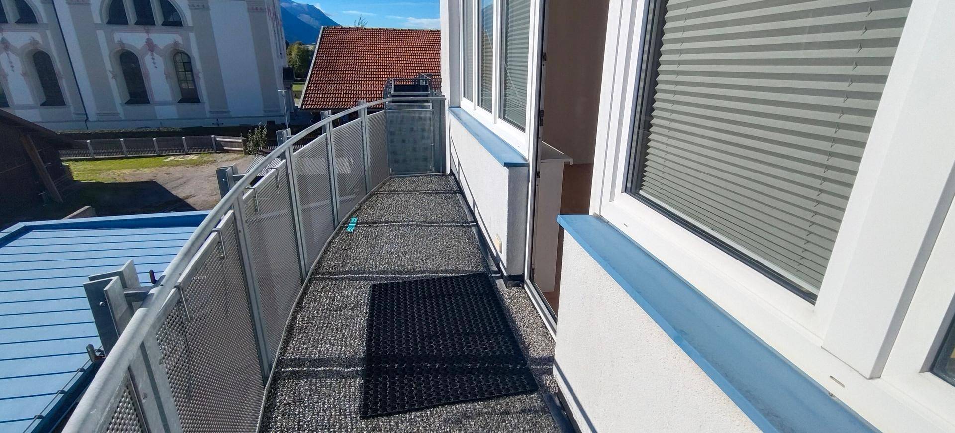 Schmaler Balkon mit Metallgeländer und Blick auf die Umgebung.