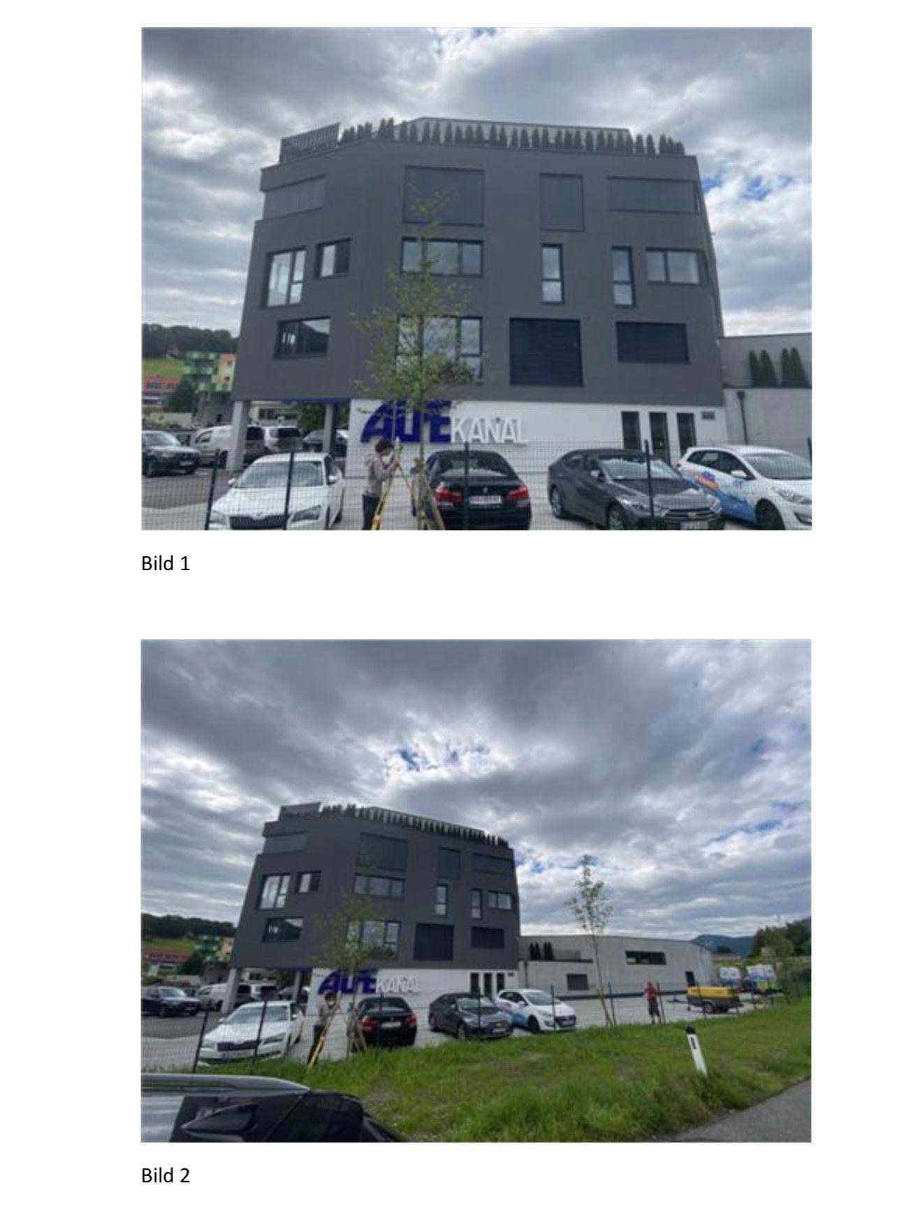 Weitwinkelansicht des modernen Bürogebäudes mit Parkplätzen und umliegender Natur.