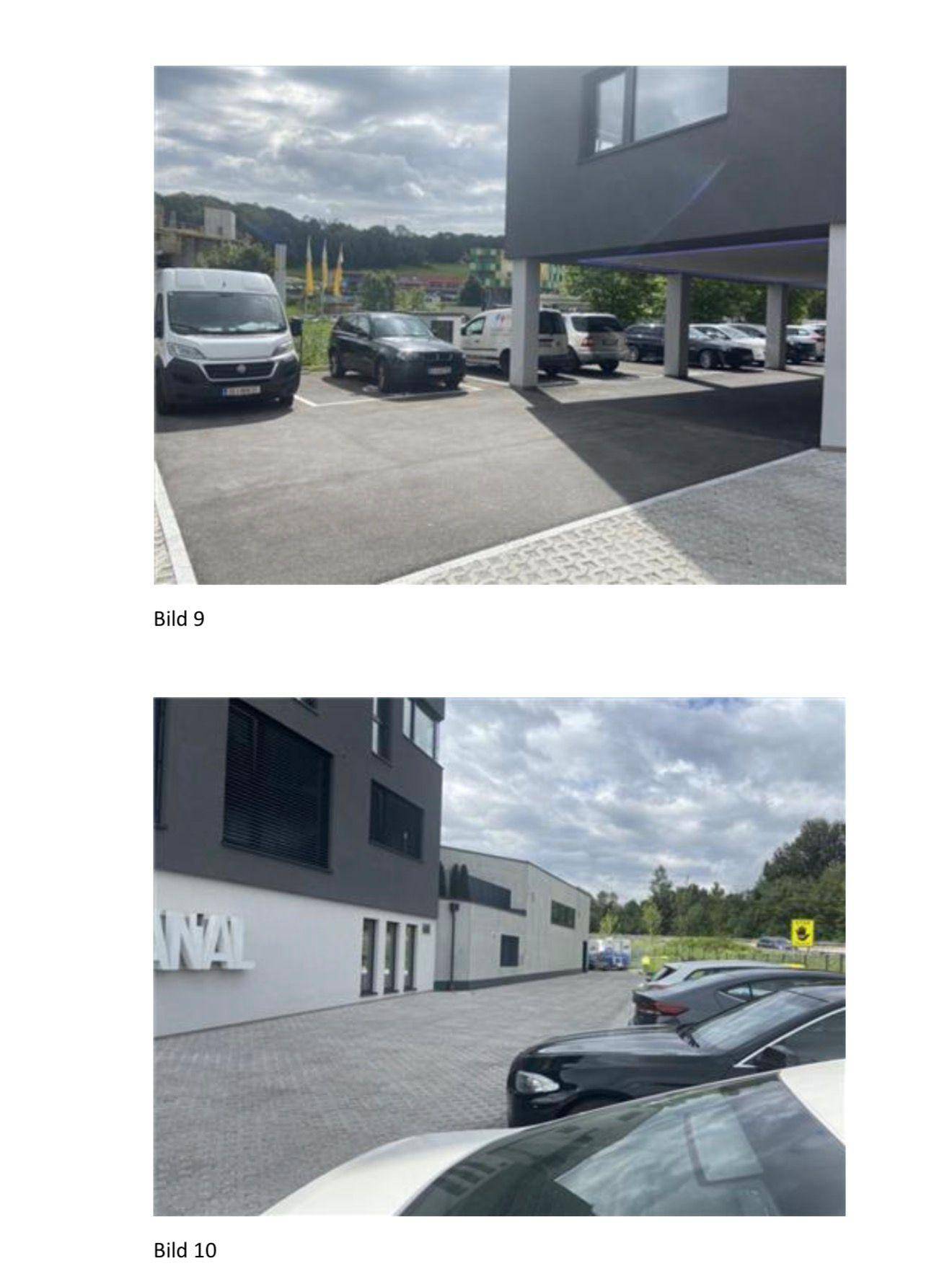 Außenansicht des Gebäudes mit gepflasterten Parkplätzen und umliegender Grünfläche.