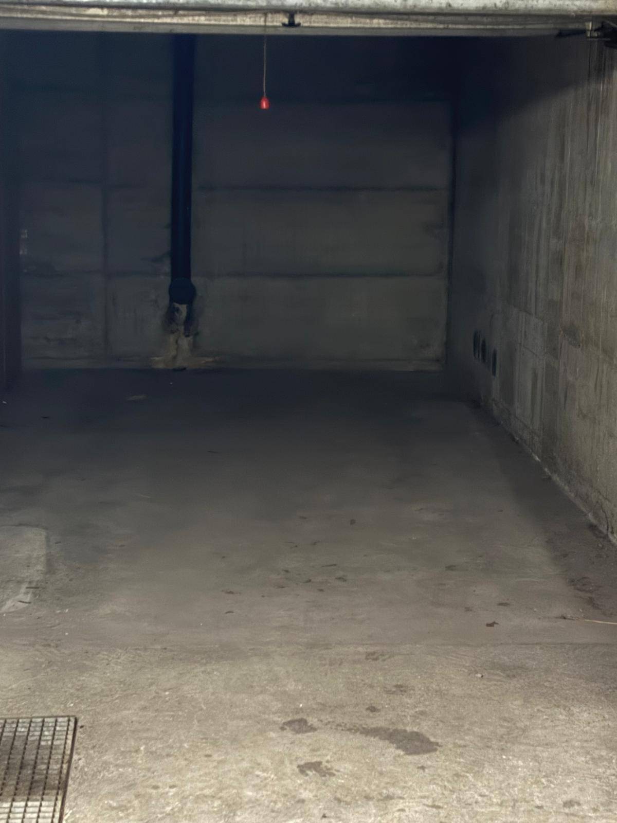 Leere Garagenbox in der Tiefgarage mit Betonwänden und robustem Betonboden.