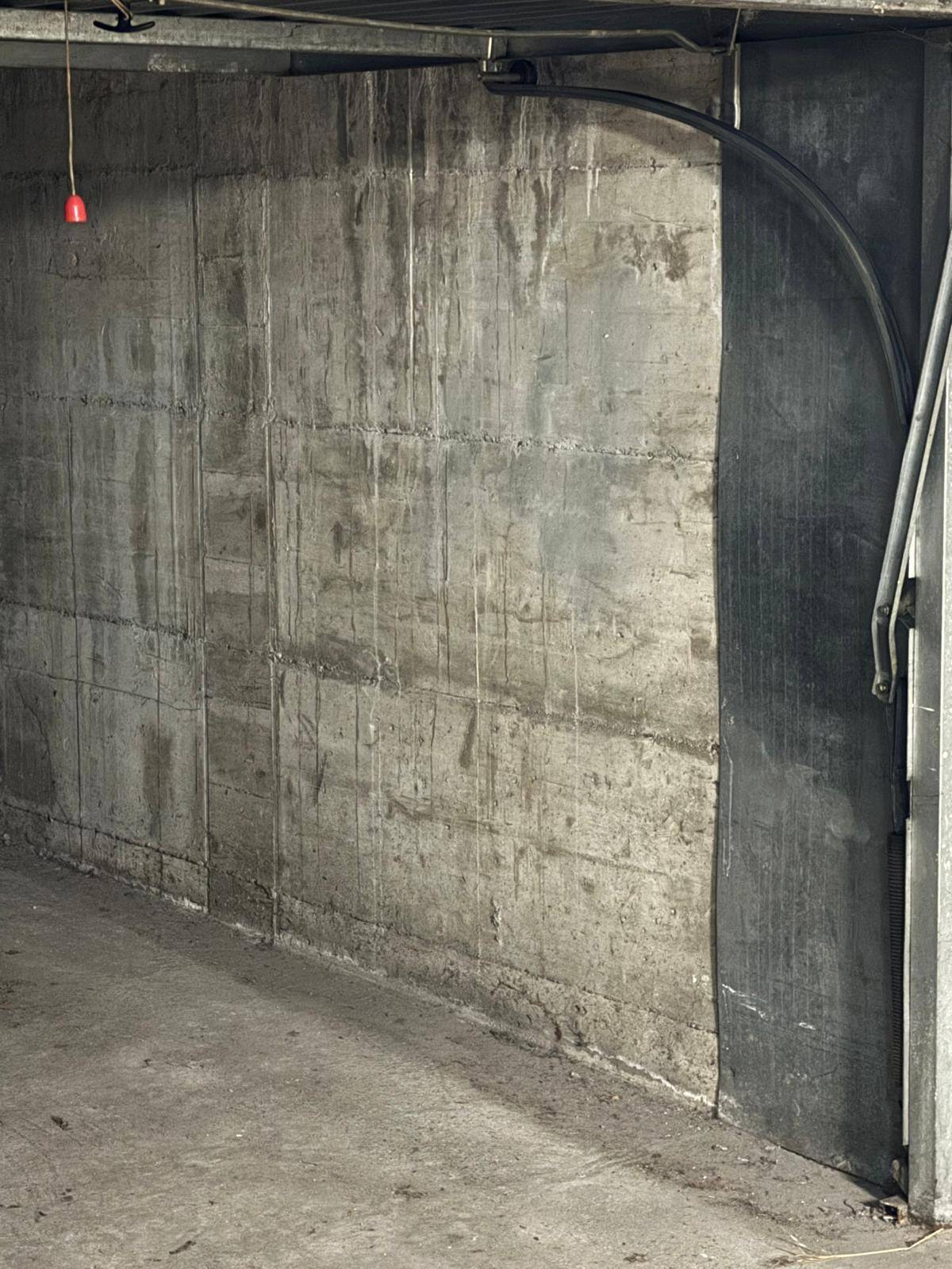 Detailansicht einer Betonwand in der Garagenbox mit sichtbarer Textur und Gebrauchsspuren.