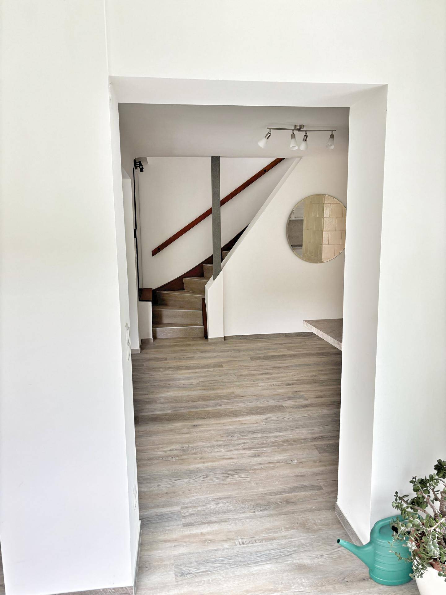 Heller Flurbereich mit Zugang zur Treppe, die in die oberen Etagen führt.