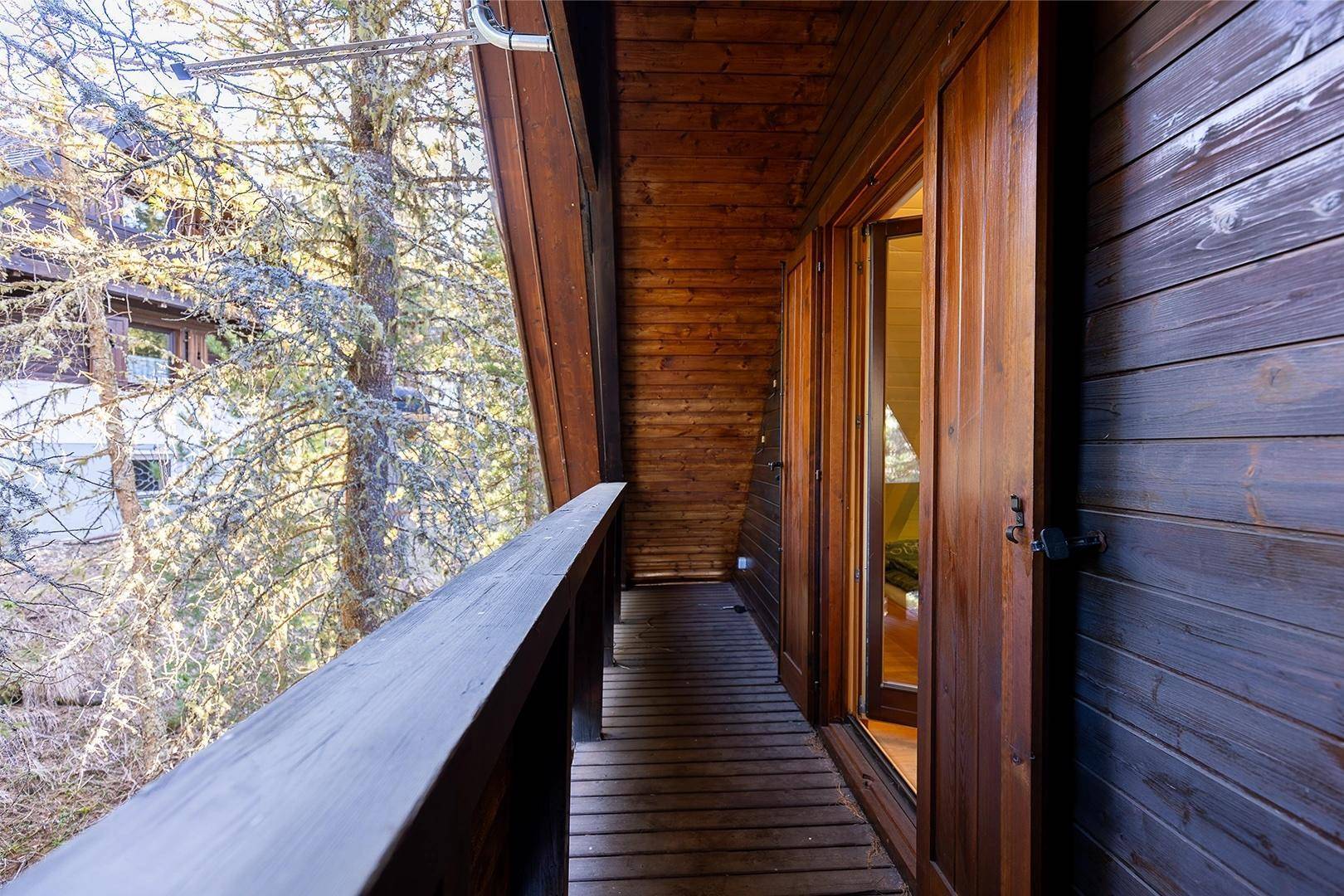 Holzbalkon mit Blick auf Bäume und die umliegende Natur, ideal zum Entspannen im Freien.