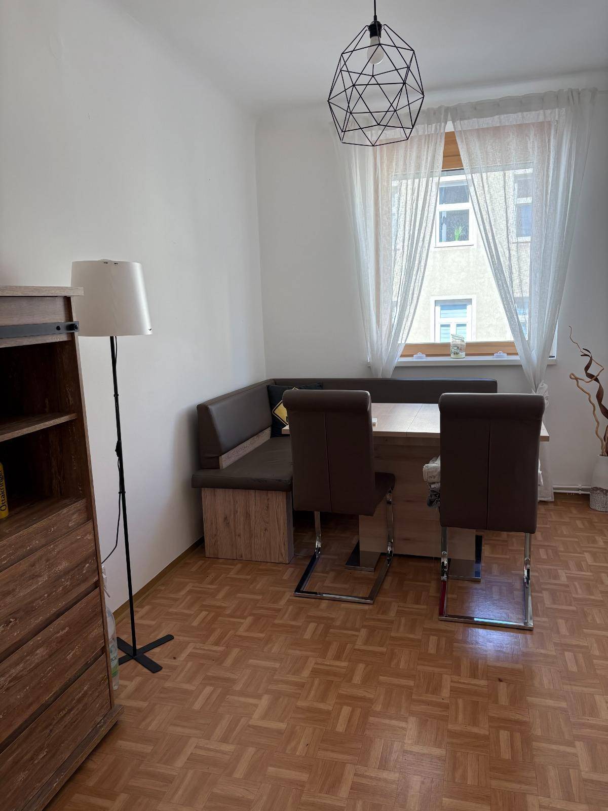 Gemütlicher Essbereich mit Eckbank, Holztisch und Parkettboden.