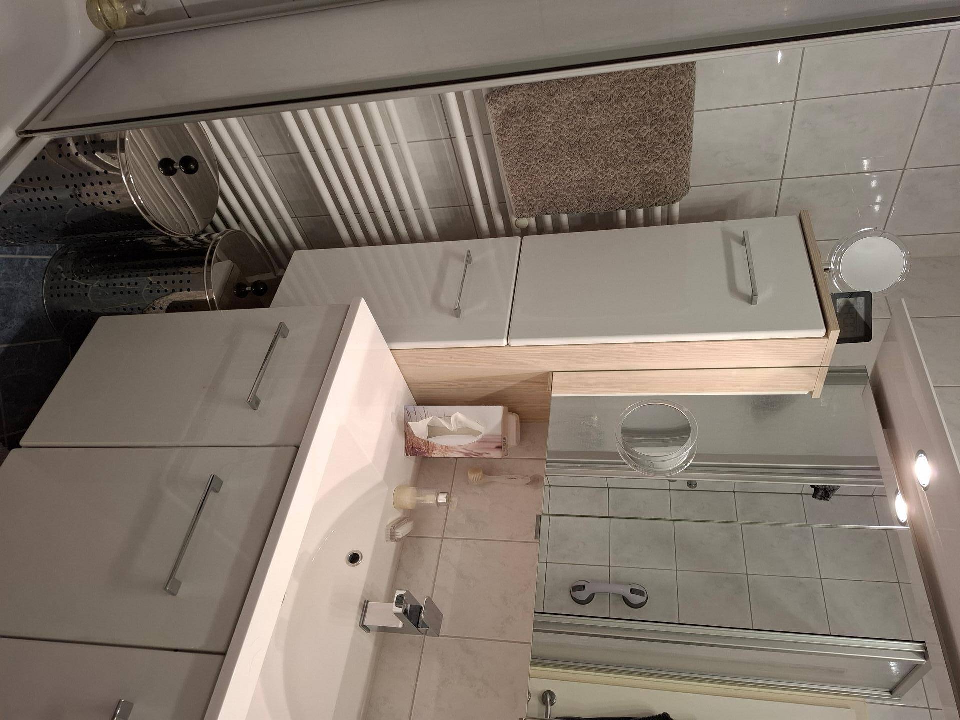 Modernes Badezimmer mit Waschbecken, Spiegelschrank und beheiztem Handtuchhalter.
