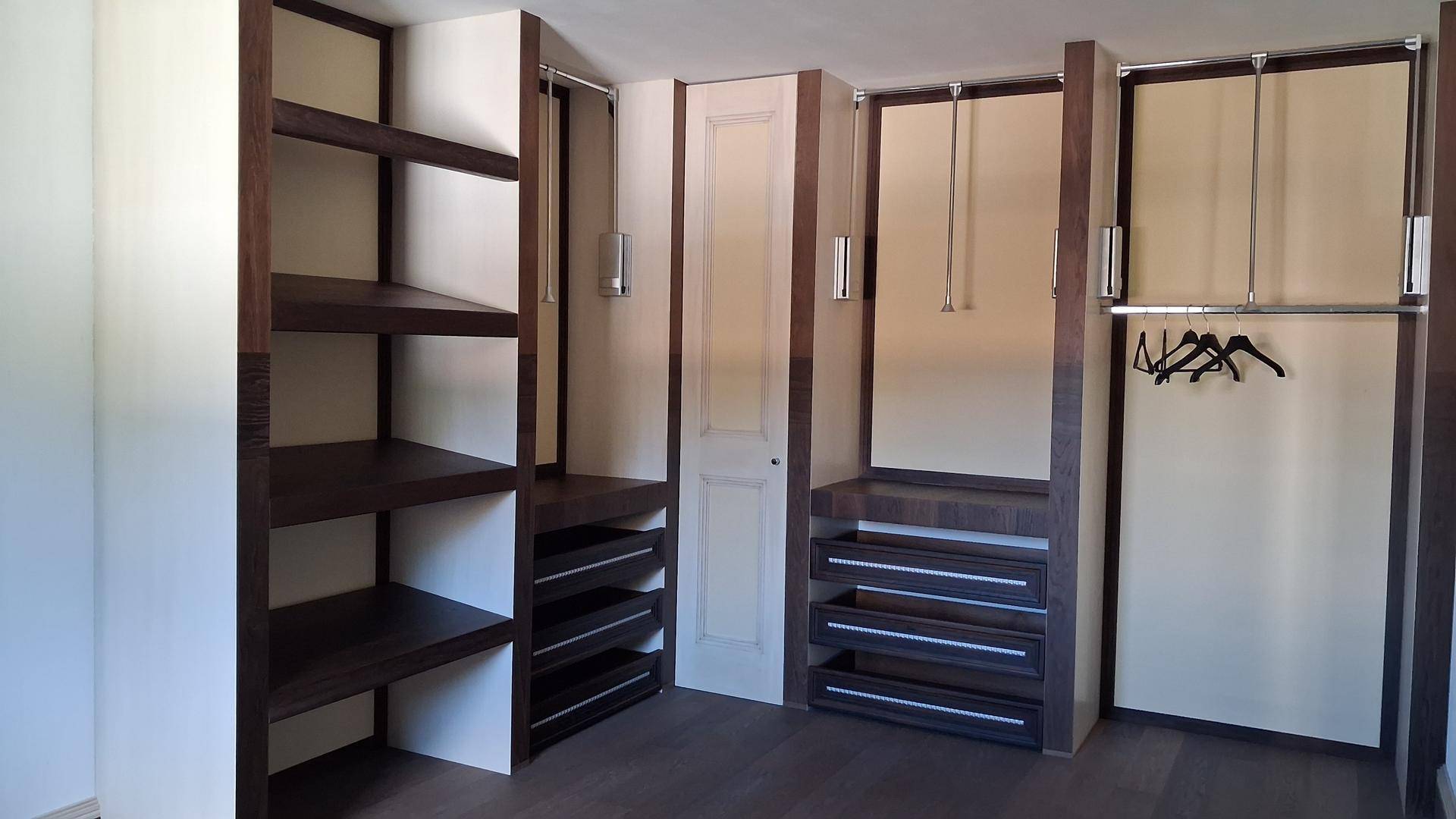 Begehbarer Kleiderschrank mit offenen Regalen und integrierten Schubladen.