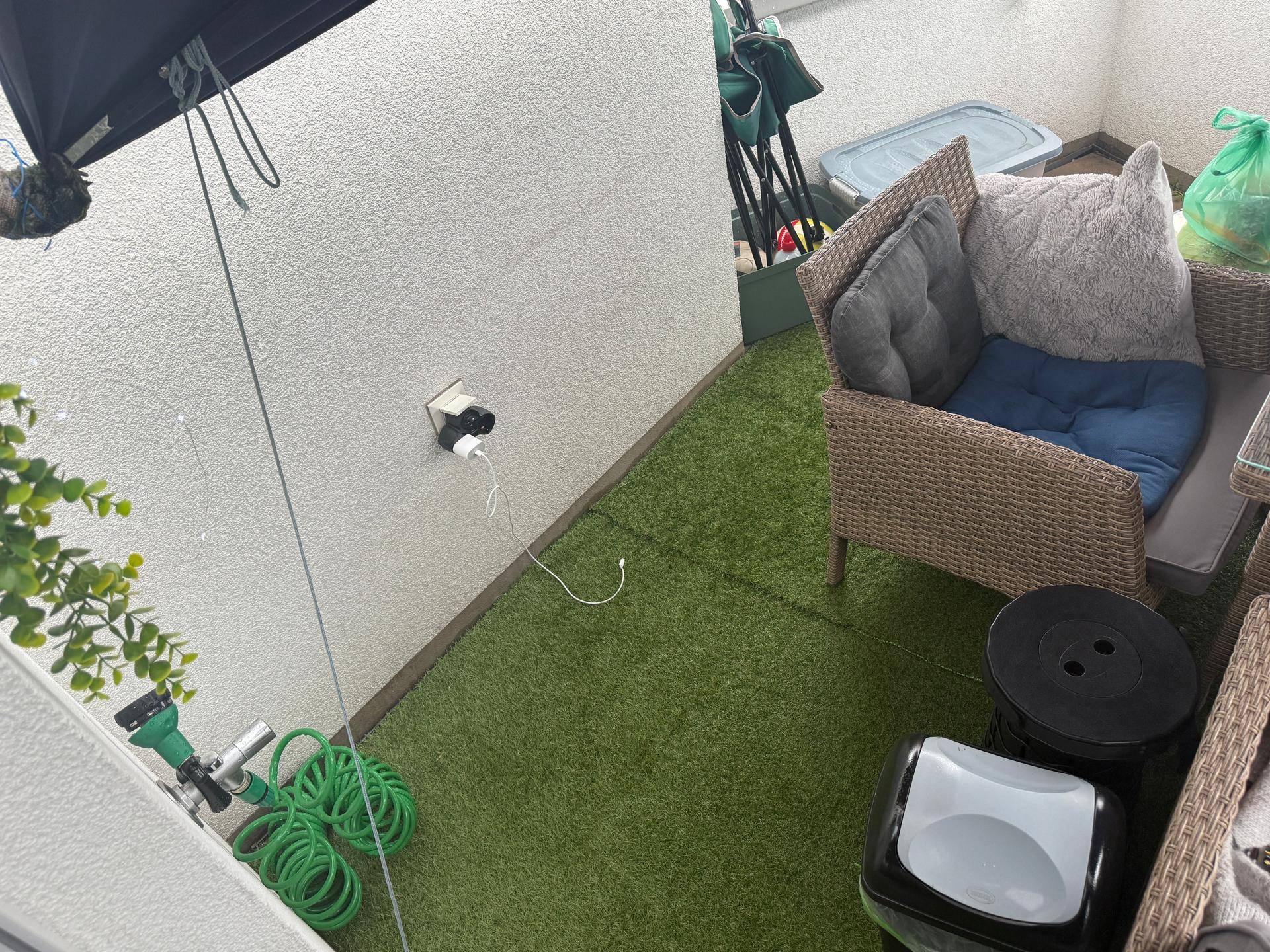 Gemütlicher Balkon mit Kunstrasen und Sitzgelegenheiten für entspannte Stunden im Freien.