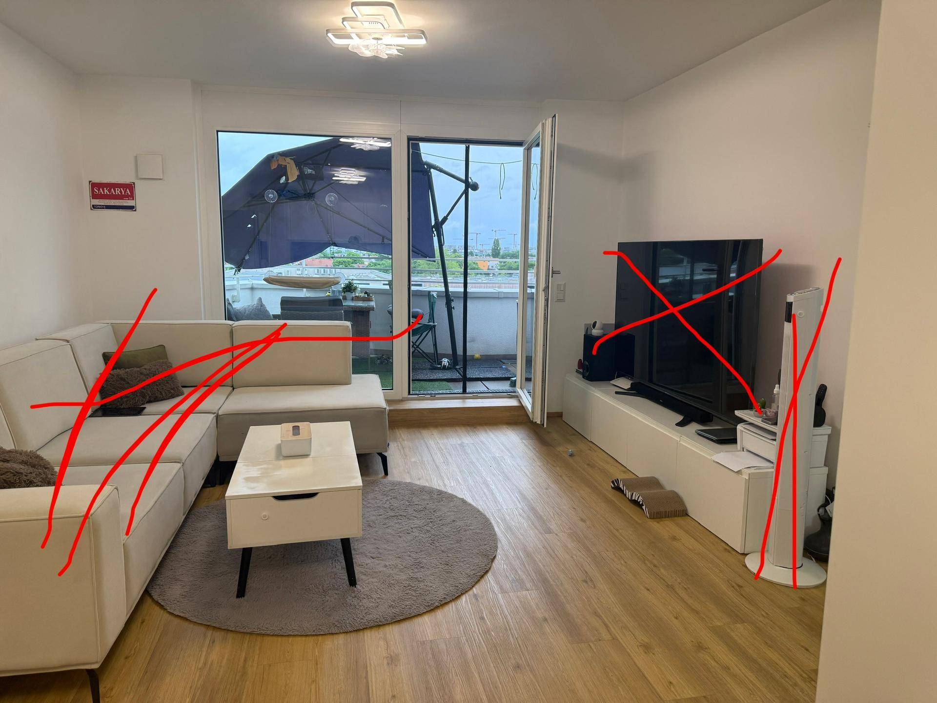 Helles Wohnzimmer mit Sofa, Couchtisch und Zugang zu einem möblierten Außenbereich.