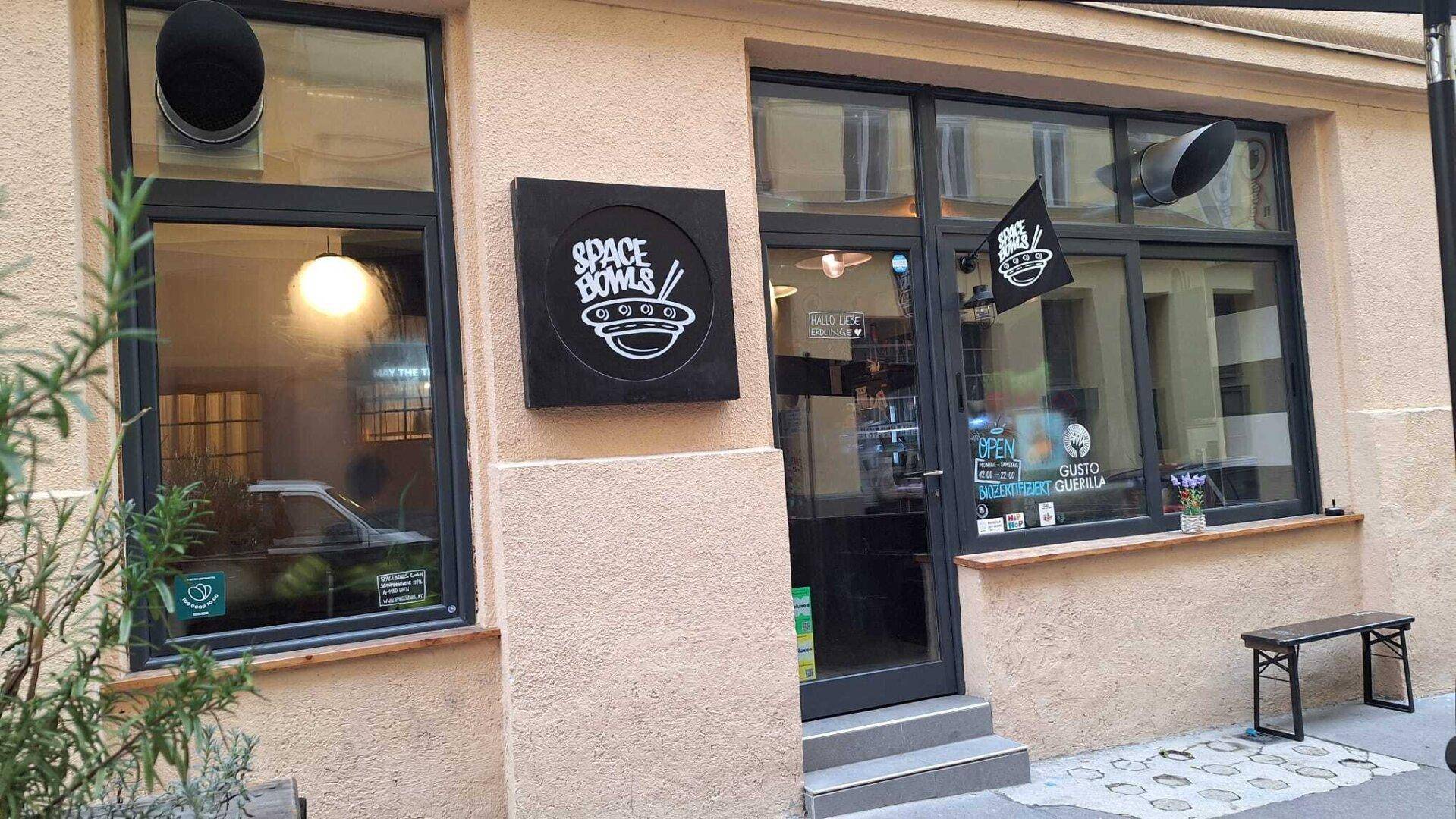 Fassade eines Geschäfts mit großen Fenstern, einer Eingangstür und einem prominenten Firmenschild.