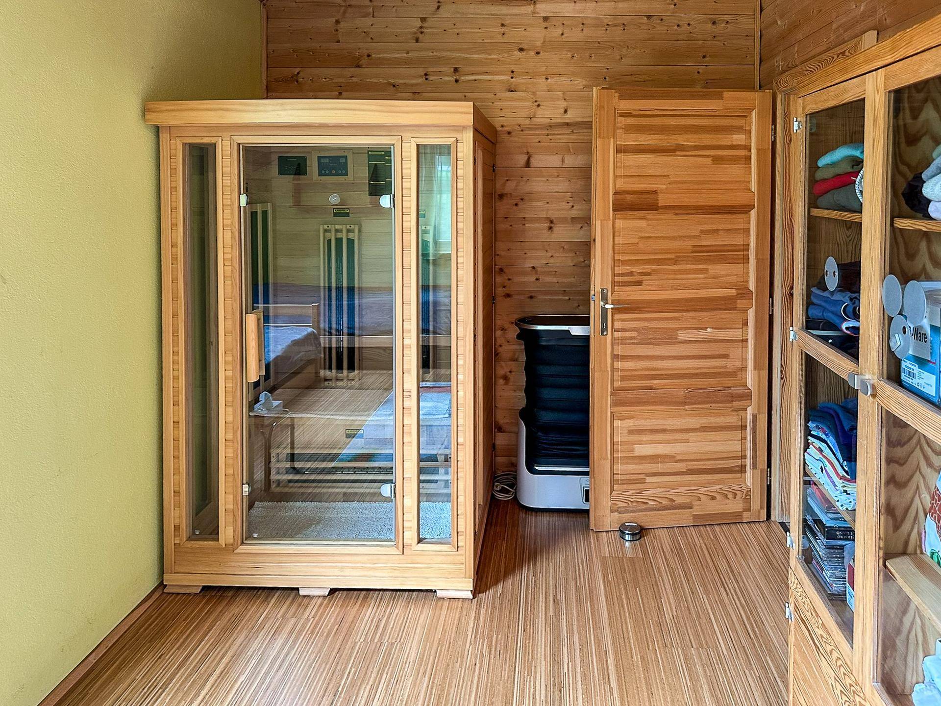 Privater Wellnessbereich mit einer modernen Infrarotsauna und Holzverkleidung an Wänden und Decke.