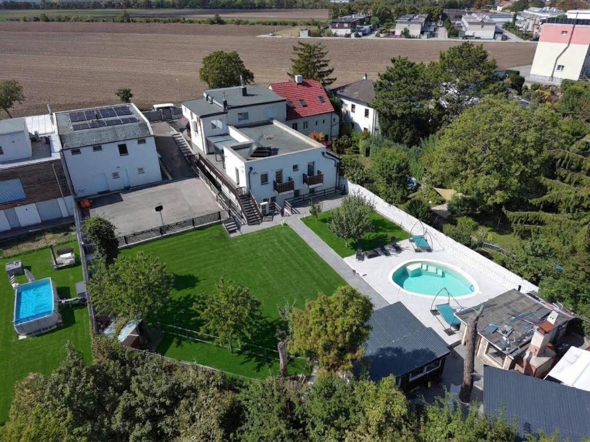 Weitläufiger Gartenbereich mit großem Rasen, Swimmingpool und angrenzenden Gebäuden.