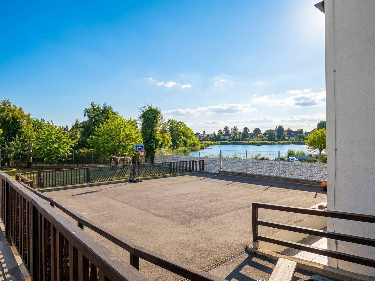 Großer Außenbereich mit Sportplatz und weitem Blick auf den See.