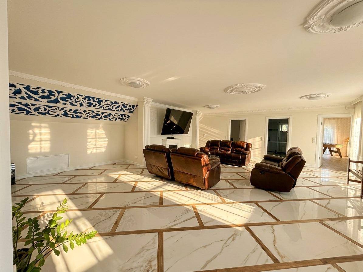 Großzügiges Wohnzimmer mit eleganten Fliesen, Stuckdecken und bequemen Ledersofas.