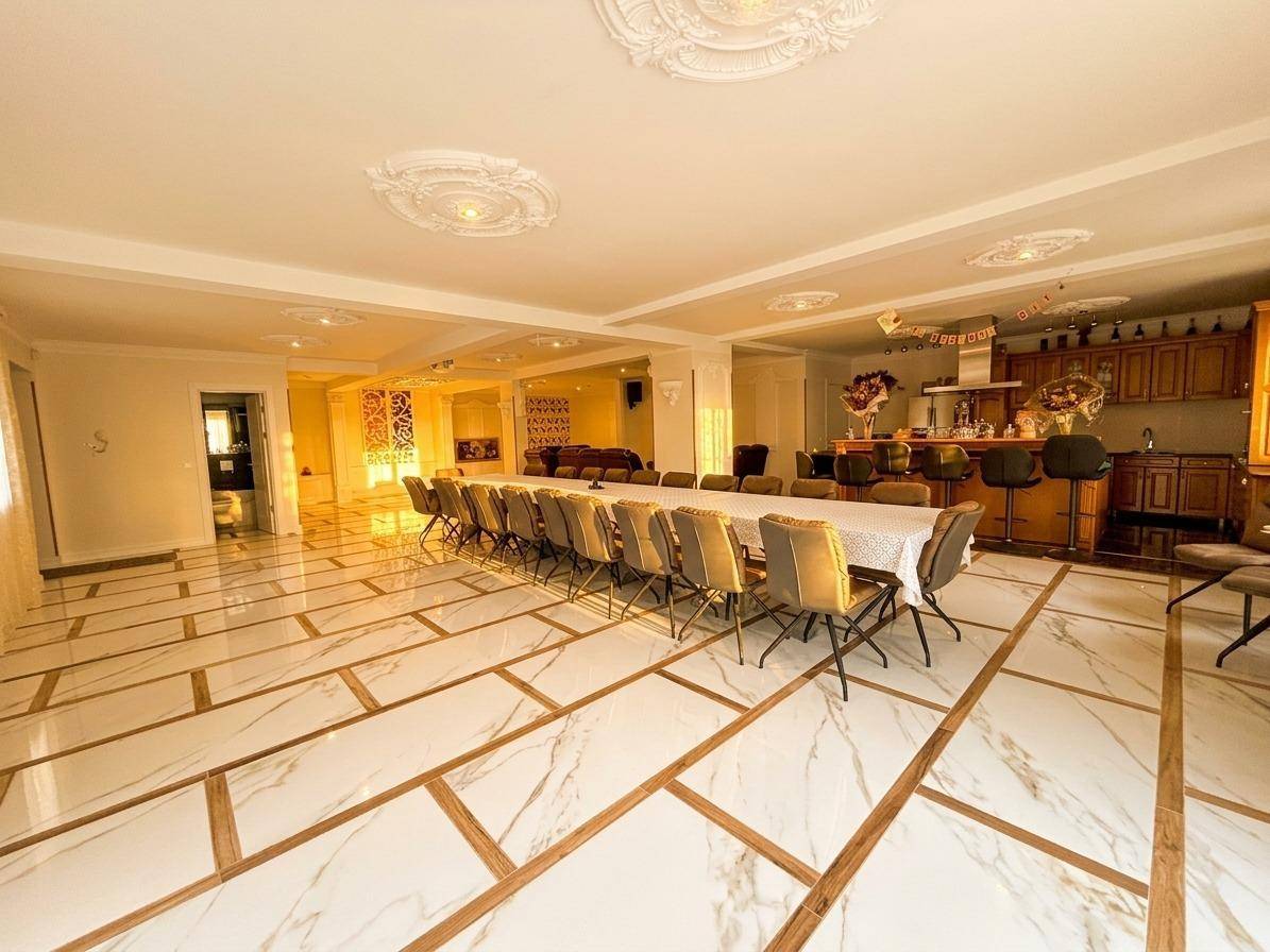 Großer Essbereich mit langer Tafel, Bar und eleganten Fliesen, ideal für Veranstaltungen.