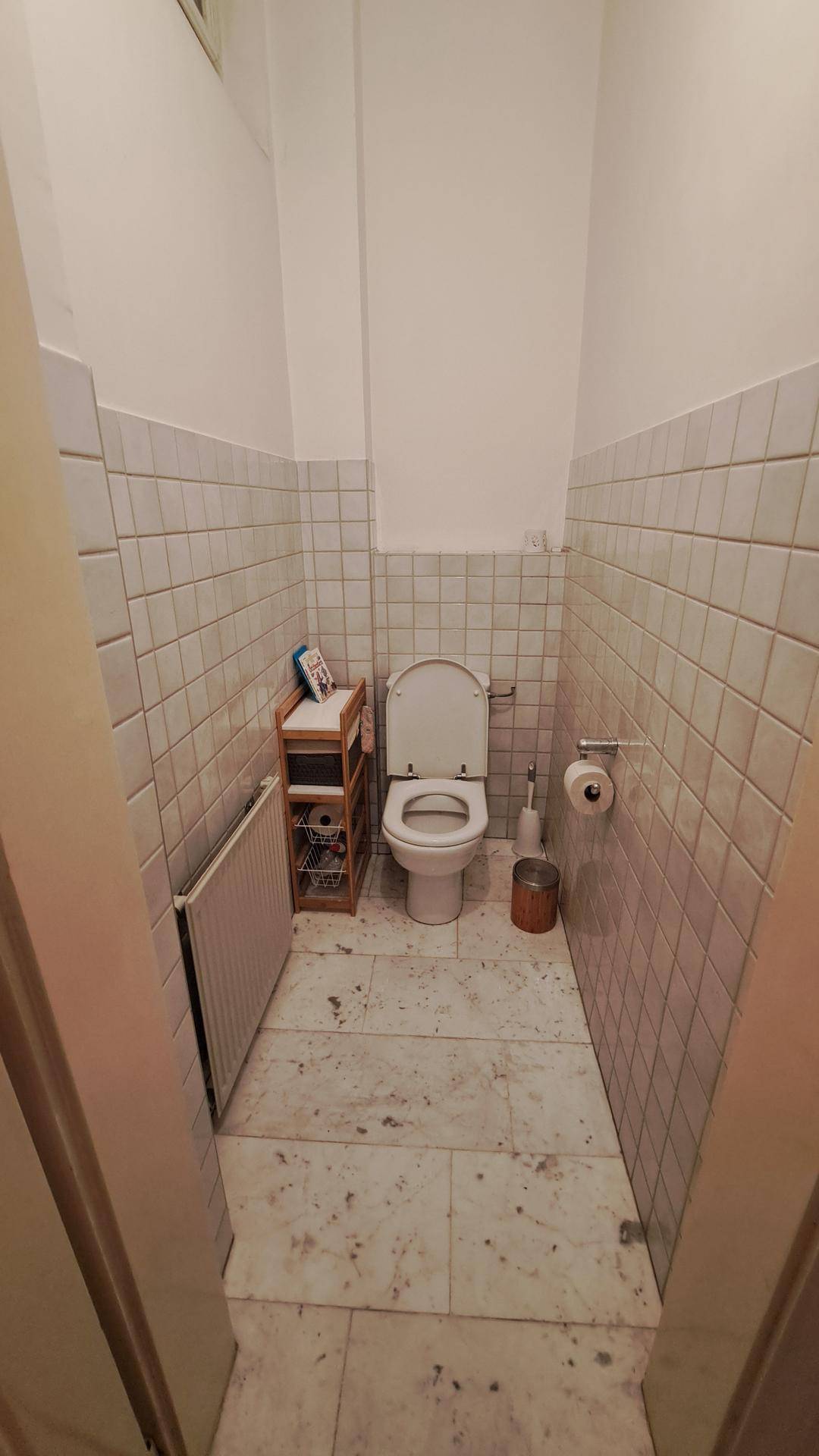 Kleines Gäste-WC mit weißen Fliesen und einer einfachen, funktionalen Ausstattung.