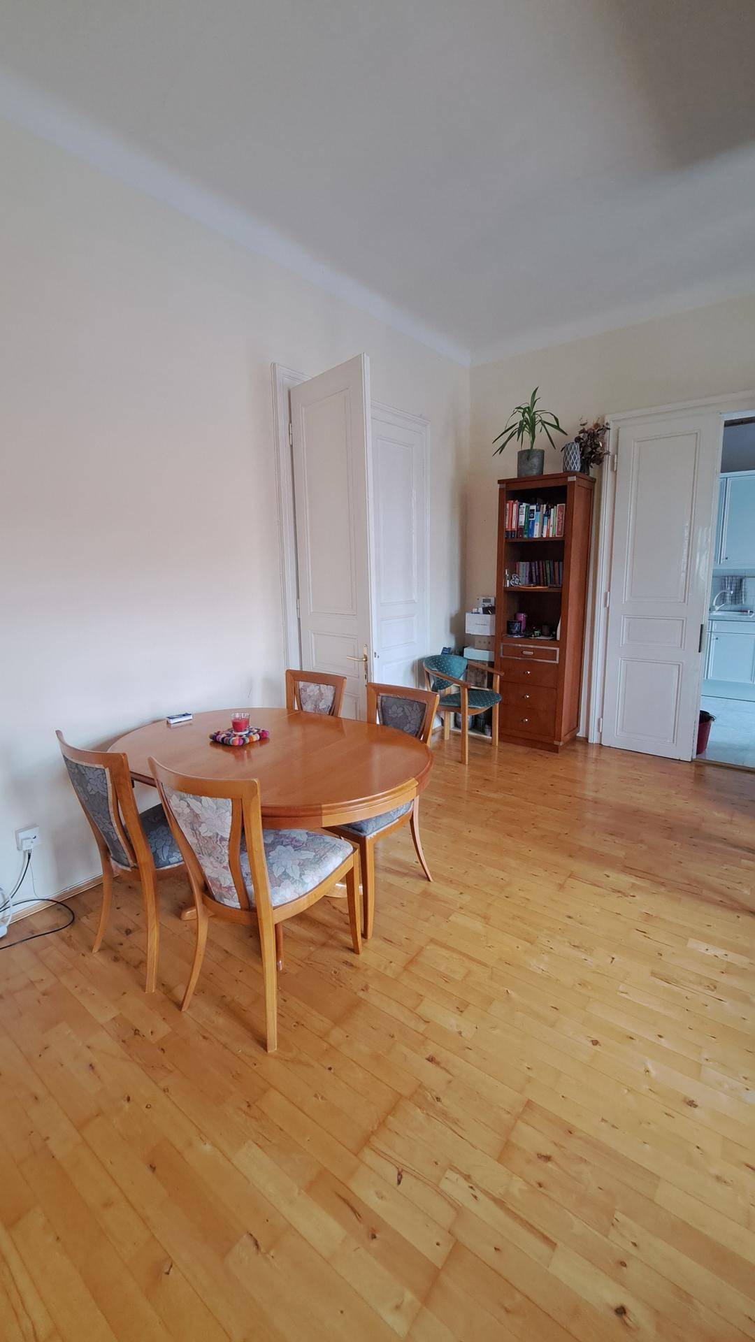 Heller Essbereich mit Holzboden und einem runden Holztisch mit passenden Stühlen, ideal für Familienmahlzeiten.